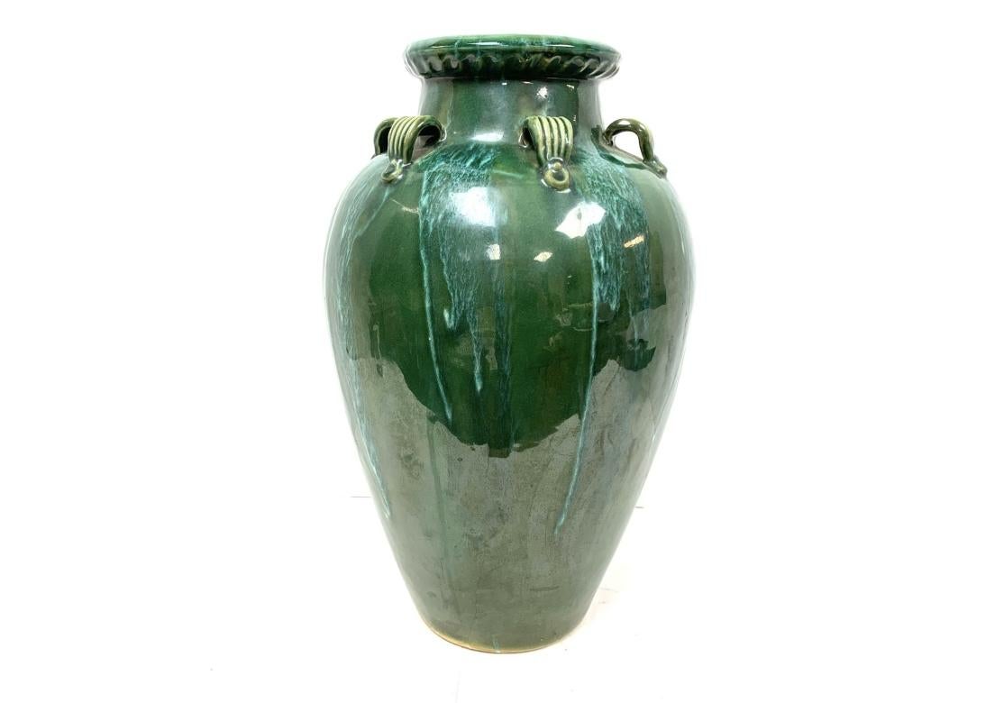 Chinese Martaban pottery floor vase with green drip glaze and distinctive fluted handles. The vase exhibits a fine traditional form and strong pleasing color. 

Dimensions: 19 1/2