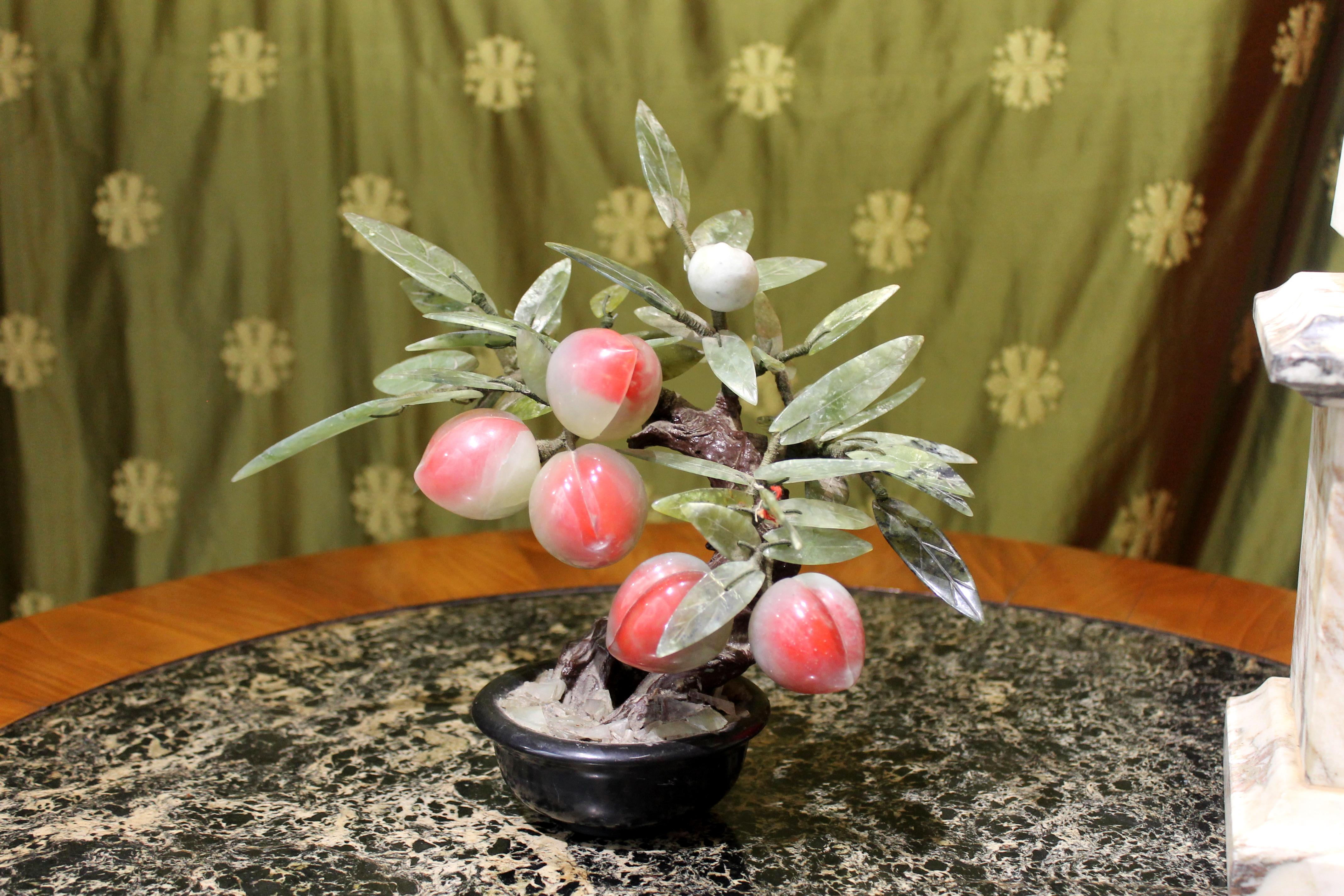 This lovely 1940s circa Chinese bonsai jade and hard stones nectarine peach tree features red and rose ripening fruit and a dense foliage with different shades of green. The branches are neatly covered in green silk threads, coming out from the