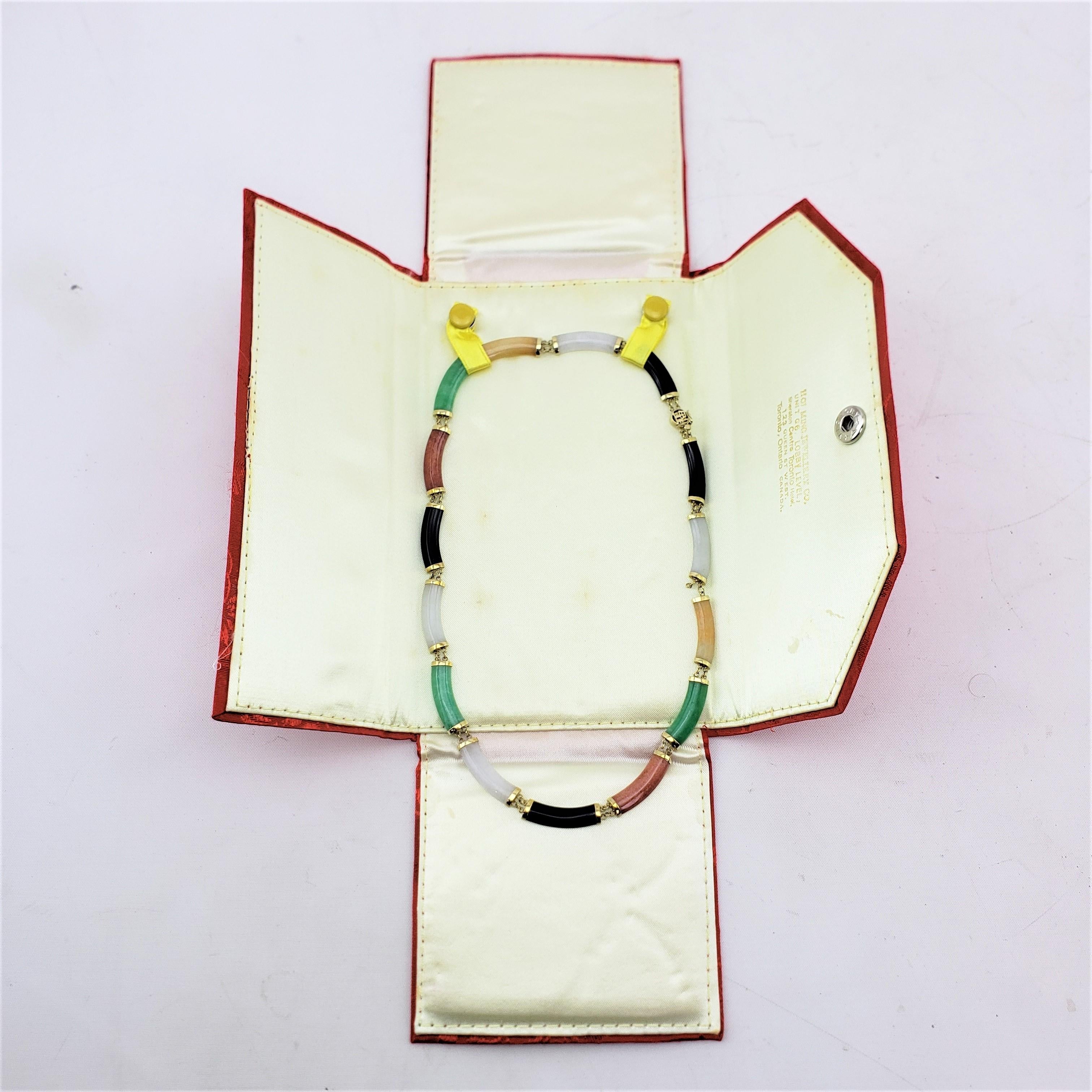 This necklace may be signed by an unknown maker, but did originate from China and date to approximately 1970 and done in the period Mid Century Modern style. The necklace is composed of 14 karat yellow gold which accents the semi--circular cut and