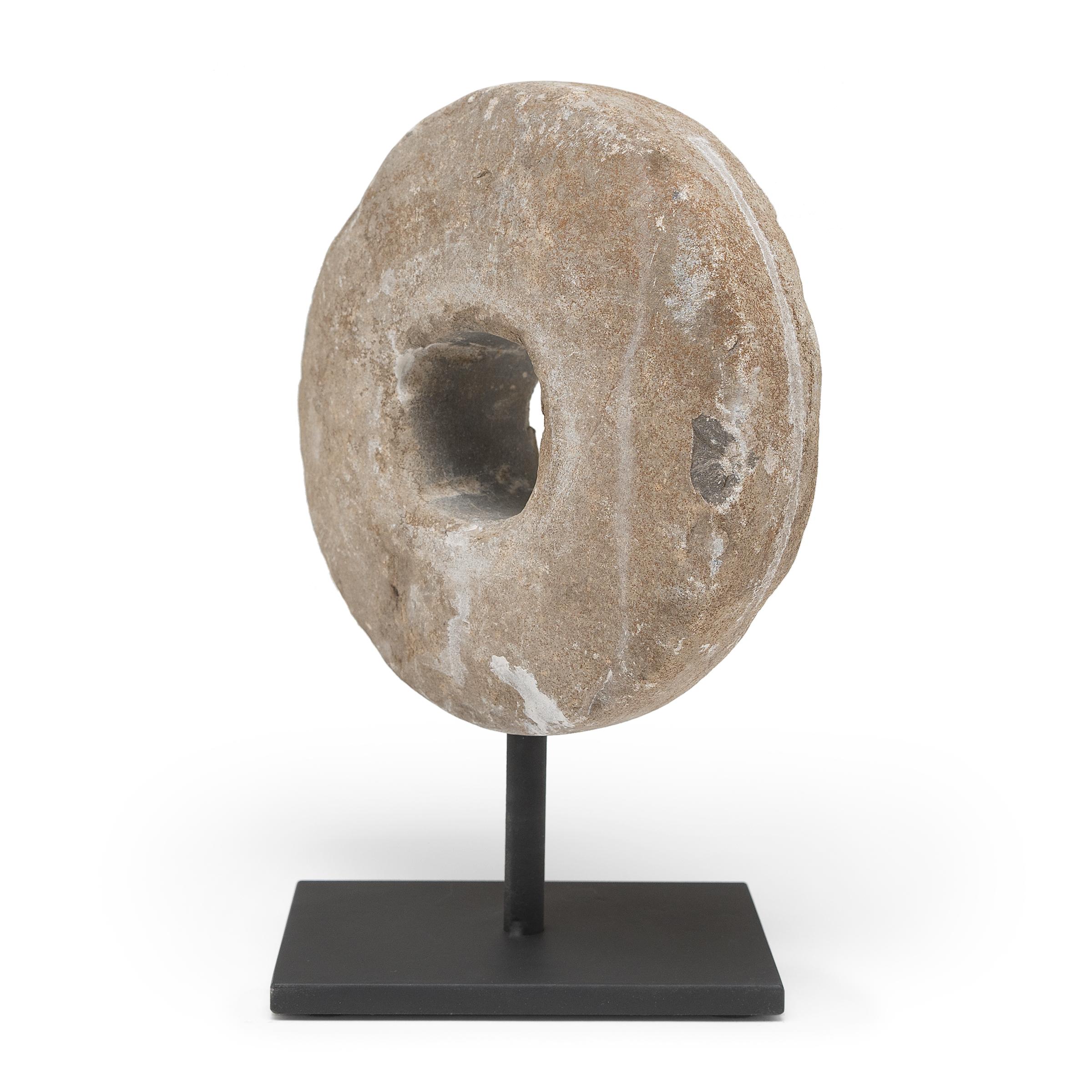 Diese runde Steinscheibe war ursprünglich eine Dreschscheibe aus dem frühen 20. Jahrhundert. Befestigt an einer hölzernen Achse, die durch die Mitte verlief, wurde der Stein über die Weizenhalme gerollt, um die Körner zu trennen, entweder von einem