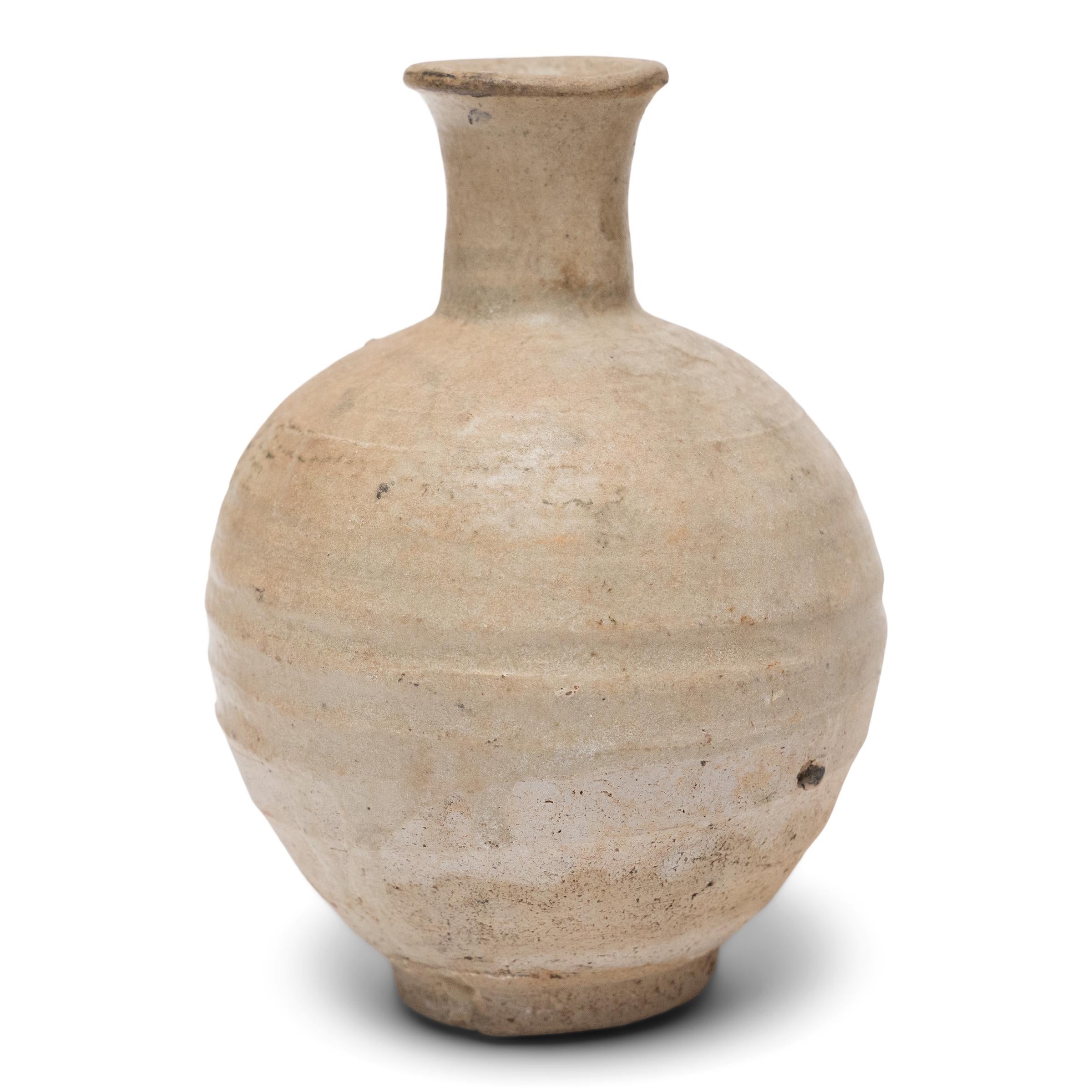 Cette petite bouteille en céramique est un récipient de la dynastie Ming (1368-1644) utilisé à l'origine pour servir de l'alcool de riz ou des spiritueux. La petite bouteille ronde est belle dans son imperfection, avec une légère asymétrie et un