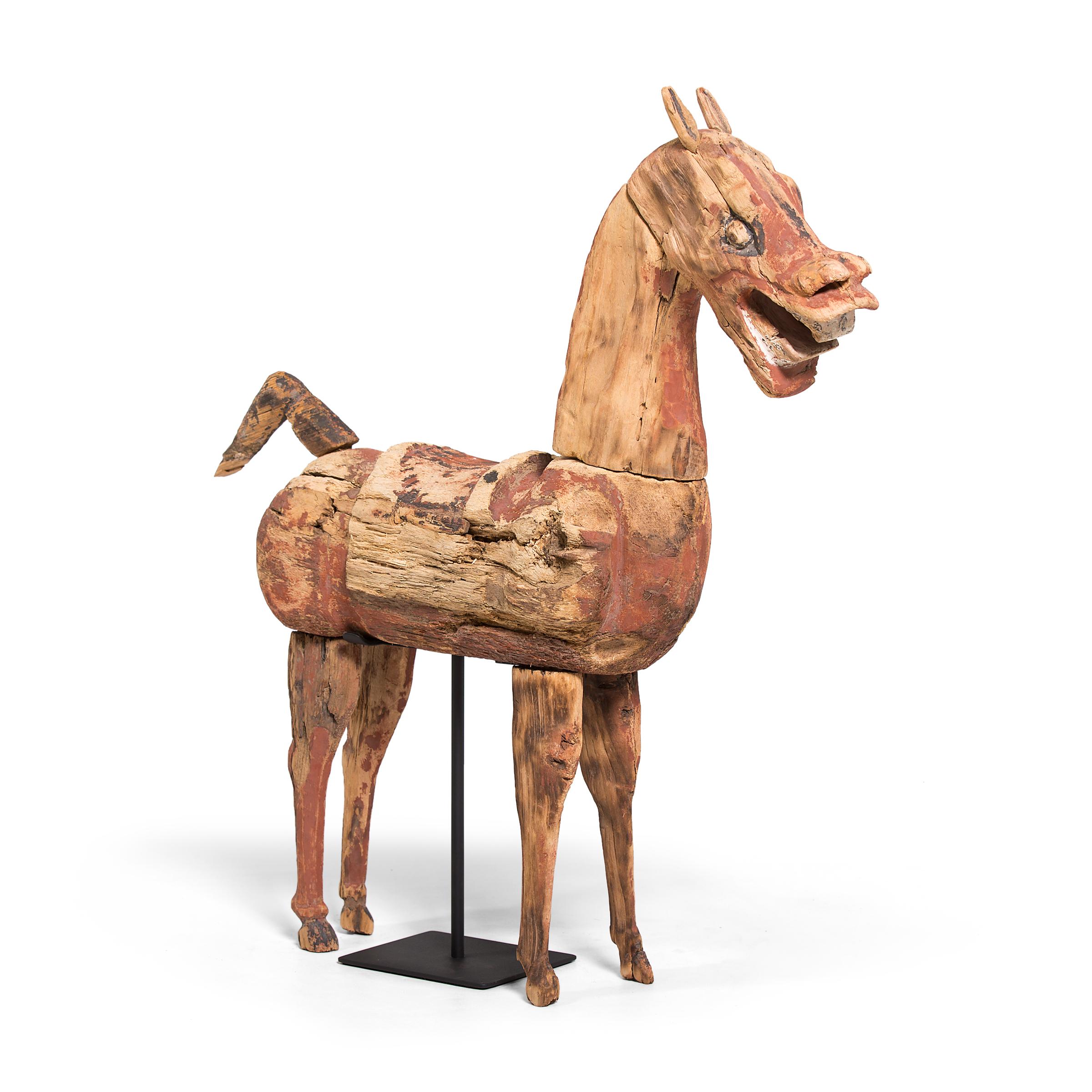 This hand carved Chinese wooden horse is a type of centuries-old burial figurine known as míngqì. Depicting the pleasures of daily life, míngqì figurines were offerings to one's spirit to ensure comfort and special treatment in the afterlife. Míngqì