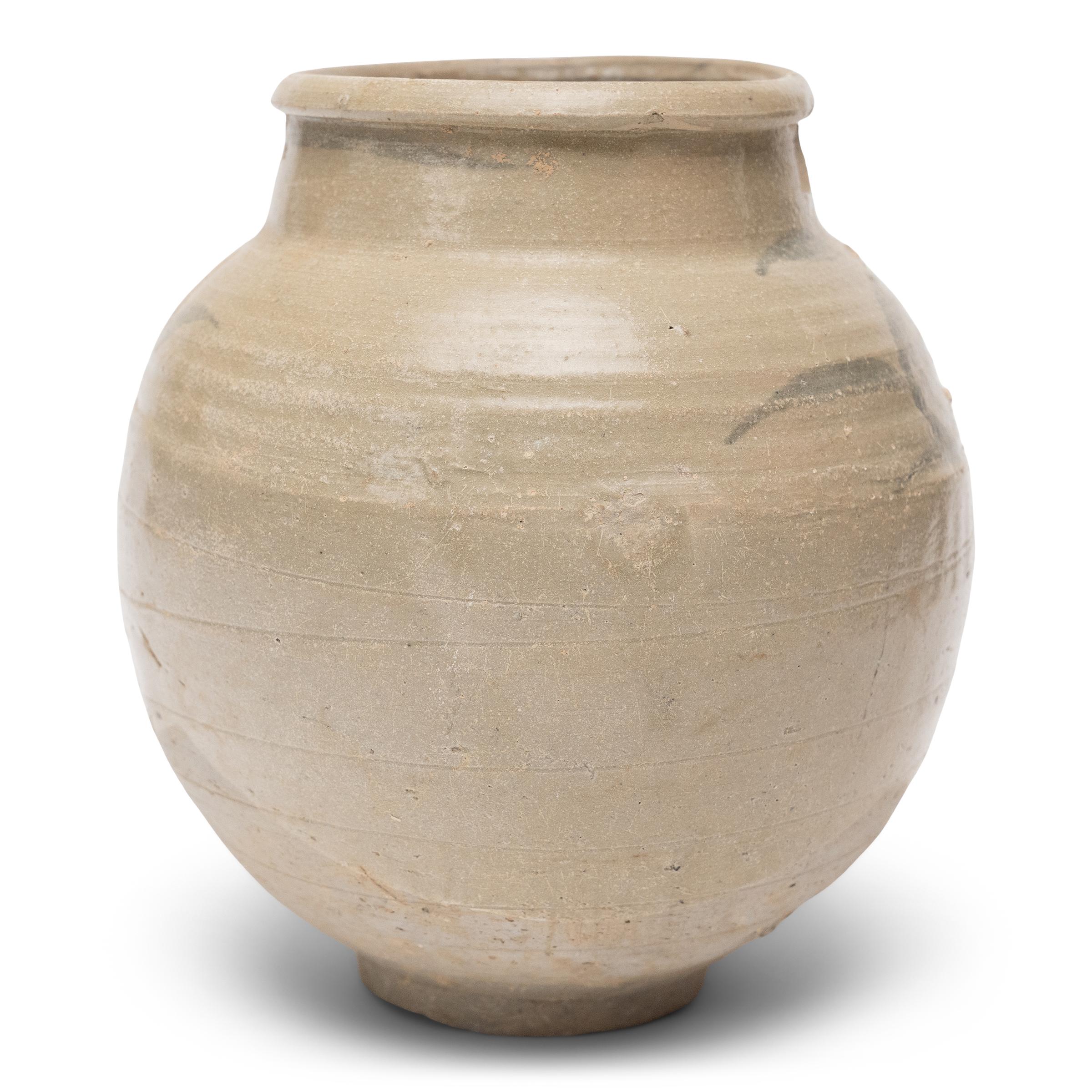 This Ming-dynasty (1368-1644) storage jar is attributed to the kilns of Yunnan province, loosely decorated with cobalt underglaze in a manner typical of the region. Dated to the 15th/16th century, the small jar is shaped to a round, globular form