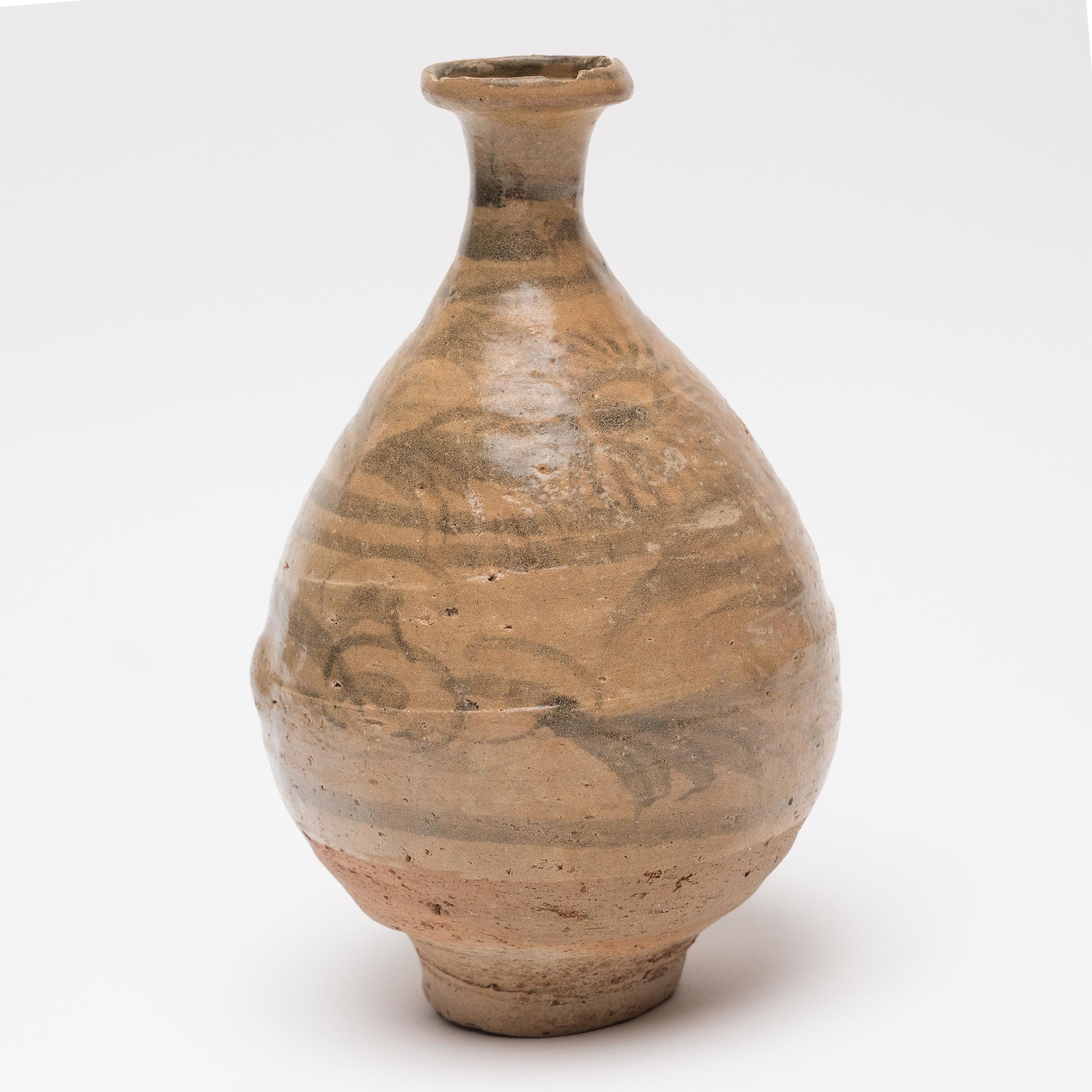 This elegant ceramic vessel is a Ming-dynasty (1368-1644) bottle originally used for storing oil or sauces. Dated to the 15th/16th century, the bottle has a gracefully curved form known as yuhuchunping, or pear-shaped vase, and is potted with a