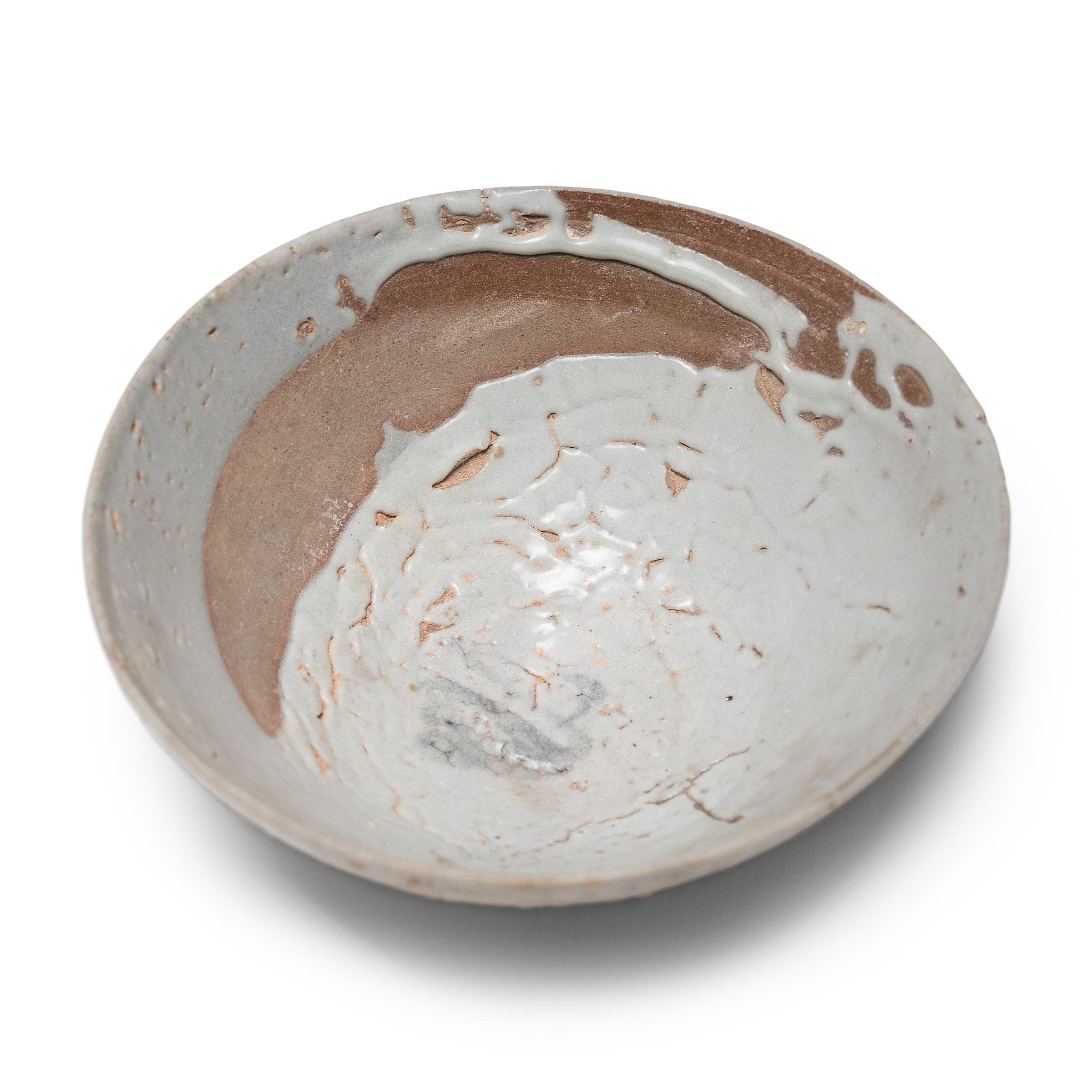 With subtle asymmetry and a dramatic, crawled glaze, this Ming-dynasty (1368-1644) bowl from Yunnan province demonstrates the wabi-sabi beauty of imperfections. The small bowl has a delicate, tapered form, finely potted with thin walls and a deep