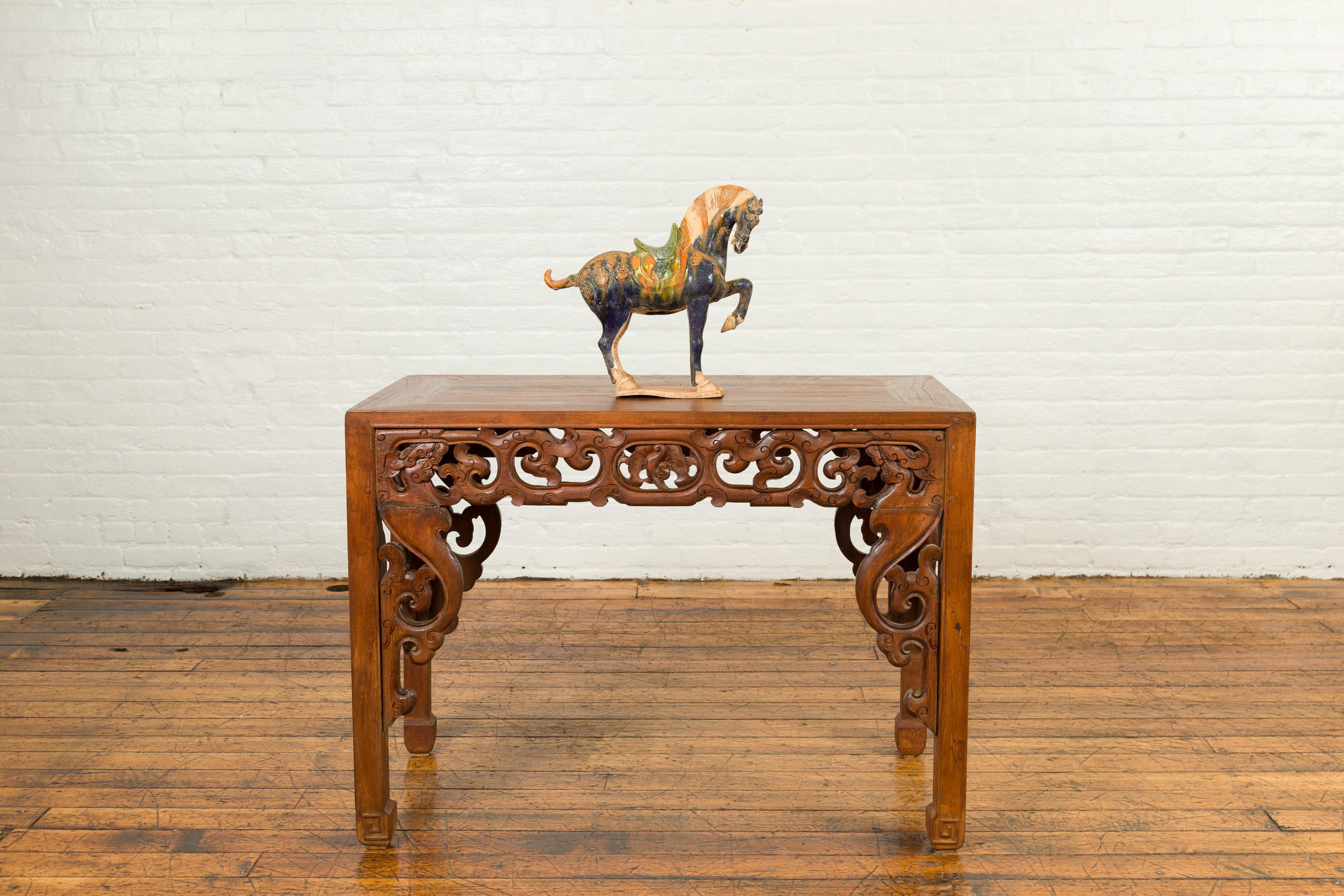 A Chinese Ming dynasty style glazed terracotta prancing horse figure from the 20th century with polychrome finish. Crafted in the Ming style, this small terracotta prancing horse attracts our attention with its graceful stance and tricolor glazed