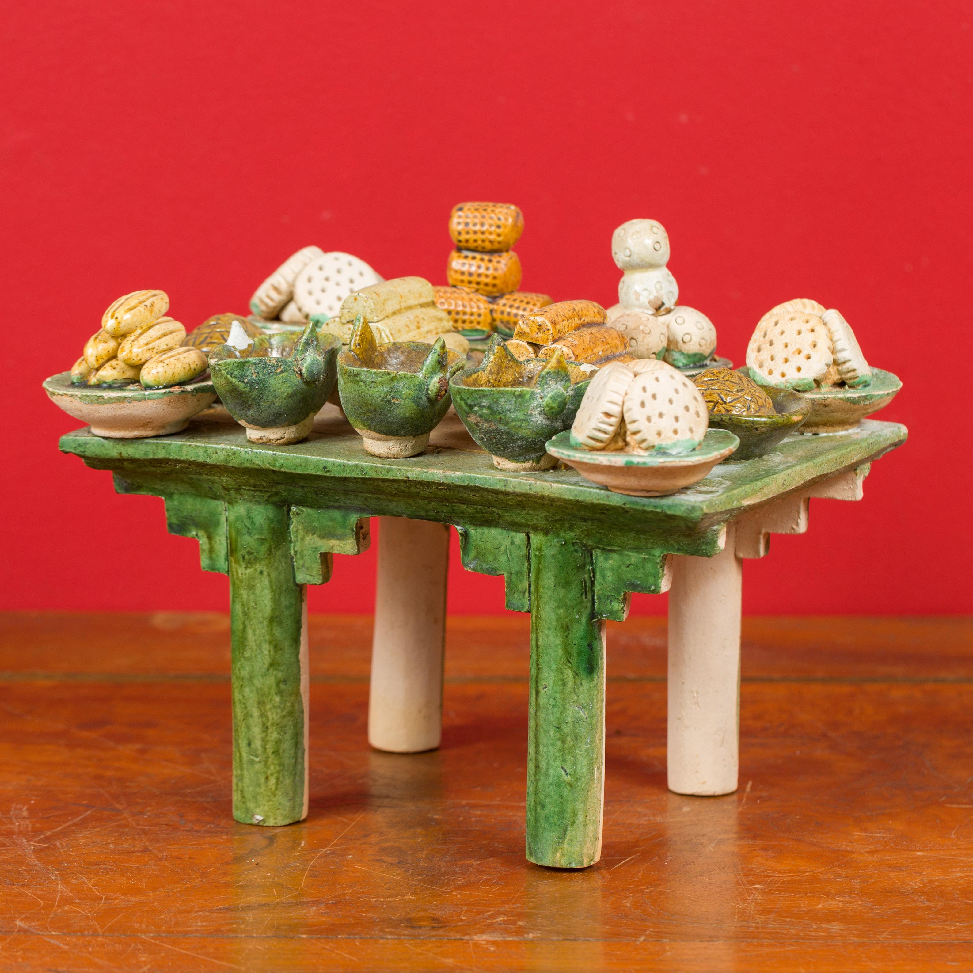 A Chinese Ming dynasty period glazed terracotta funeral table mingqi from 15th-16th century with food and drinks. Created in China during the Ming Dynasty, this terracotta funeral table showcases a typical Chinese altar, painted in green with