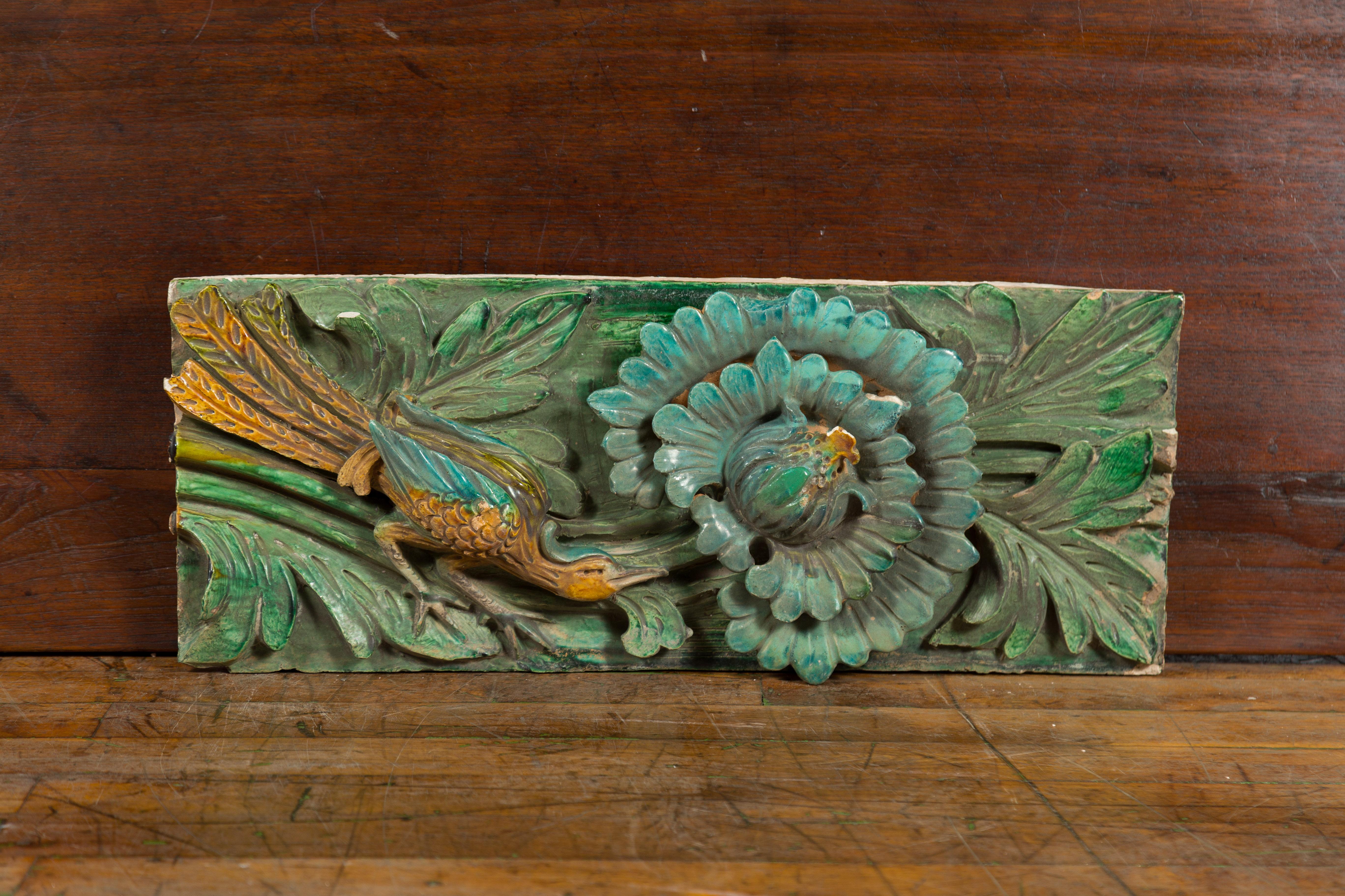 A Chinese Ming Dynasty period temple roof tile from the 17th century, with turquoise glaze, bird and flower motifs. Created in China during the Ming Dynasty which ruled from 1368 to 1644, this antique temple roof tile was made from molded terracotta