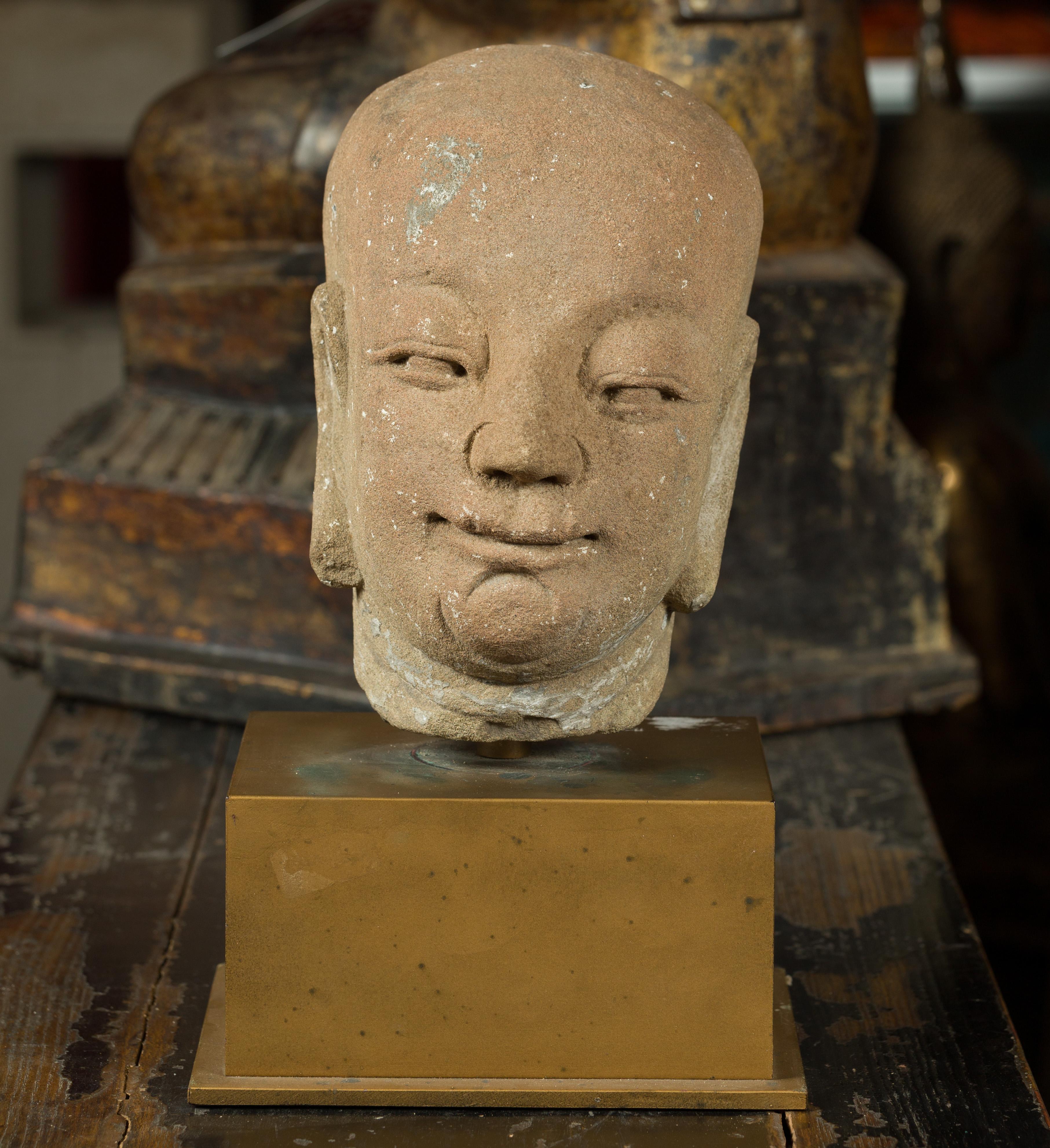 A 17th or 18th century Ming dynasty hand carved head sculpture of a serene Buddhist monk on bronze stand. This head of a Buddhist monk was hand carved in stone during the 17th or 18th century in China, then elegantly mounted on a bronze base. His