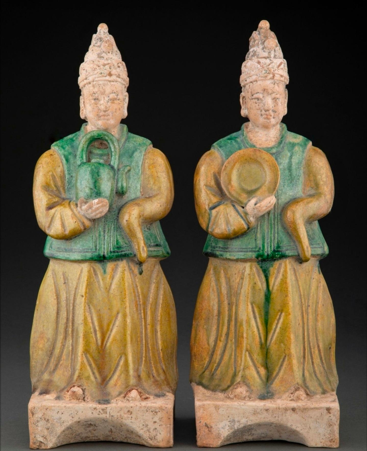 A pair of large antique Chinese polychrome ceramic attendants, Ming Dynasty (1368-1644).

Outstanding 500+ year old Sancai glazed earthenware pottery tomb figures, exceptionally executed figural form, exquisitely detailed, one holding a teapot, the