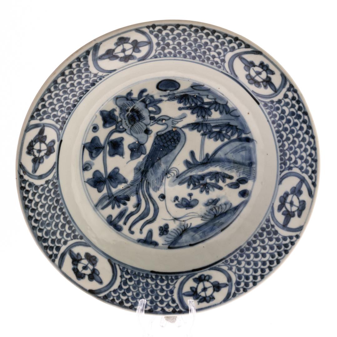 This breathtaking Chinese Ming Dynasty blue and white porcelain plate, dating to circa 1600, is a stunning example of Swatow ware, renowned for its intricate designs and exceptional craftsmanship. Featuring a vibrant, hand-painted peacock in full