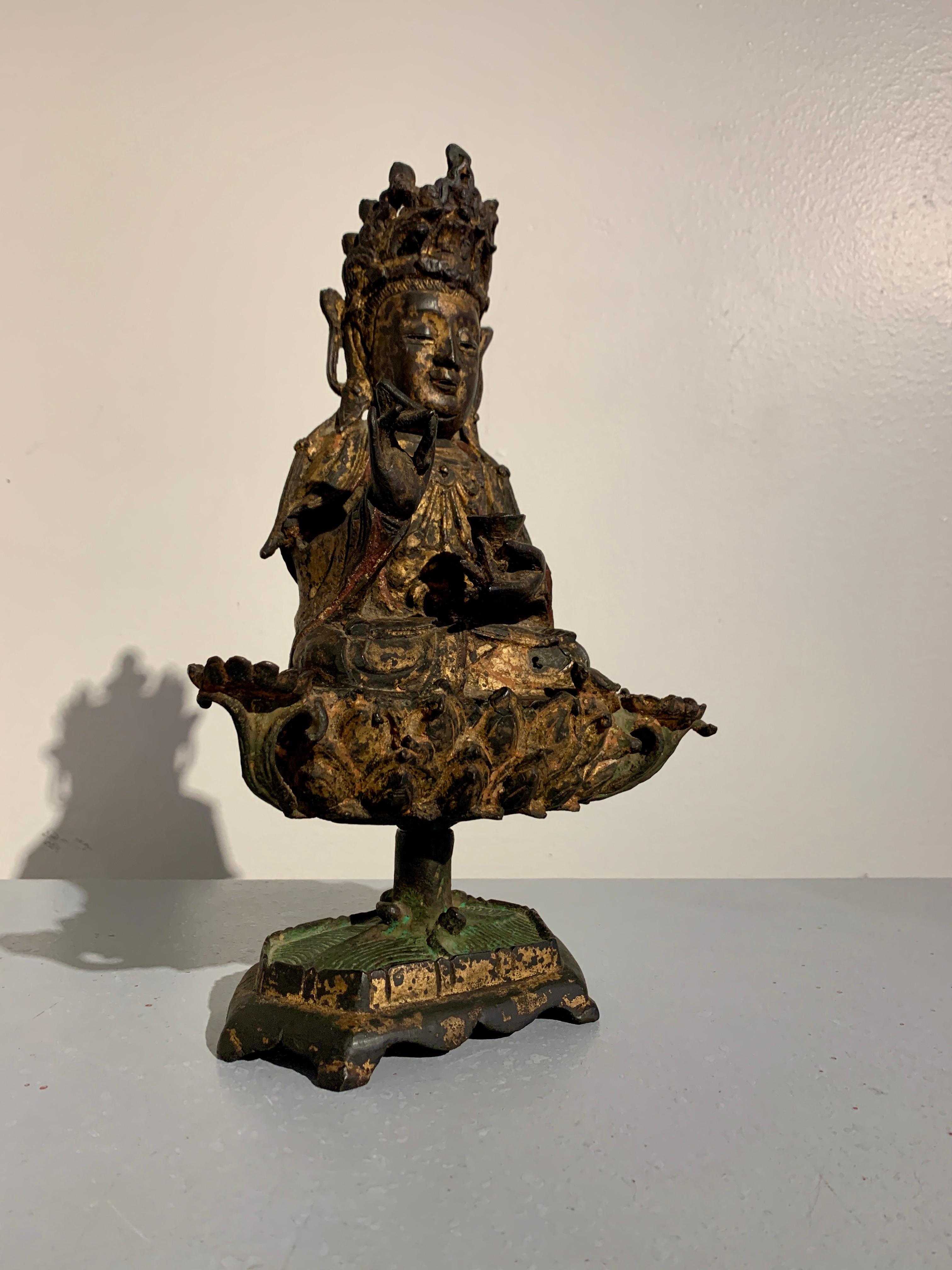 A decidingly charming Chinese polychromed and gilt cast bronze figure of Nanhai Guanyin, Guanyin of the South Sea, Ming Dynasty, 16th/17th century, China.

Guanyin, the bodhisattva of compassion, is portrayed here as a beatific figure seated upon