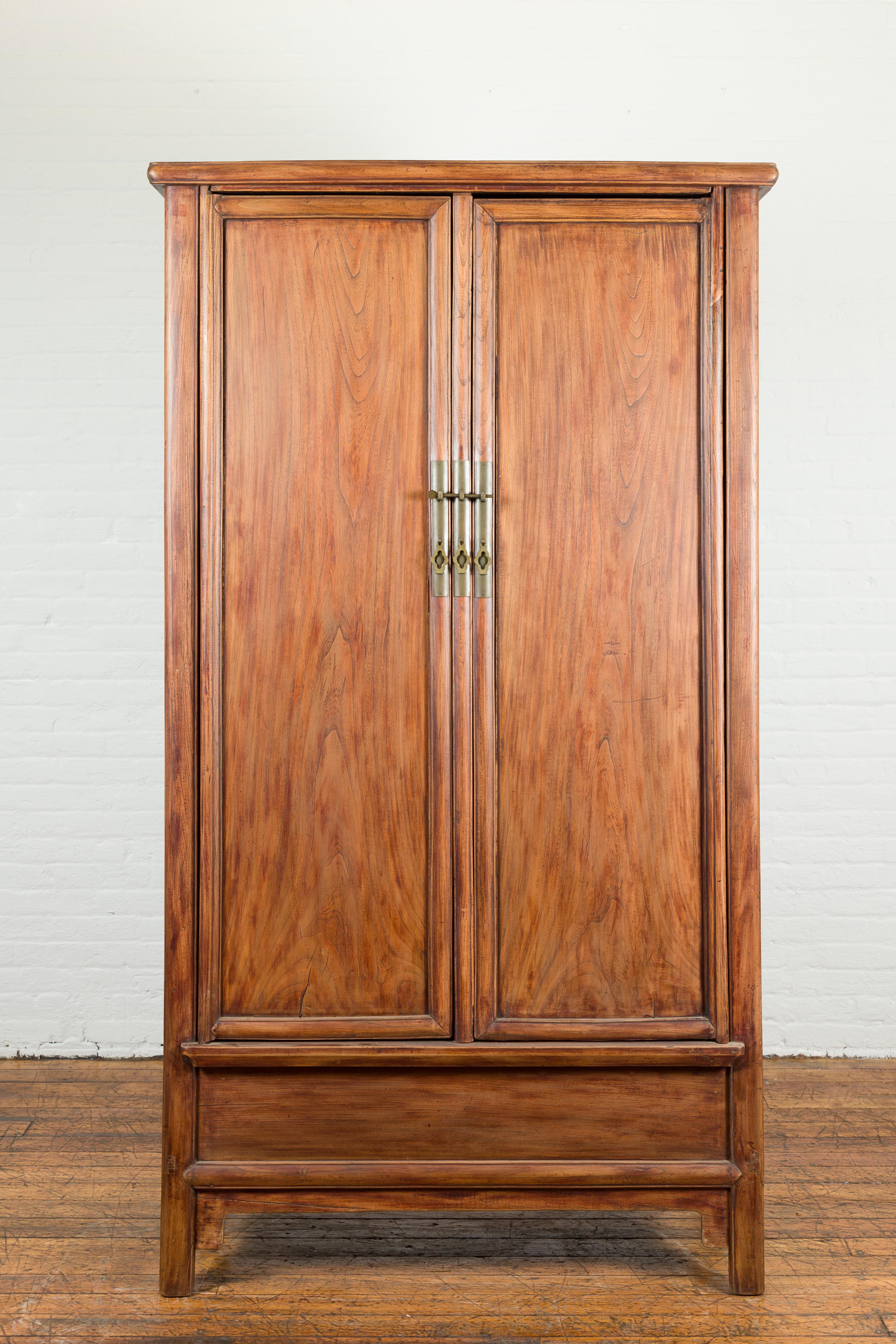 A Chinese Ming dynasty style noodle cabinet from the 19th century, with tapering silhouette. Created in China during the 19th century, this Ming dynasty style cabinet features a tapering silhouette made of two doors, fitted with brass hardware. The