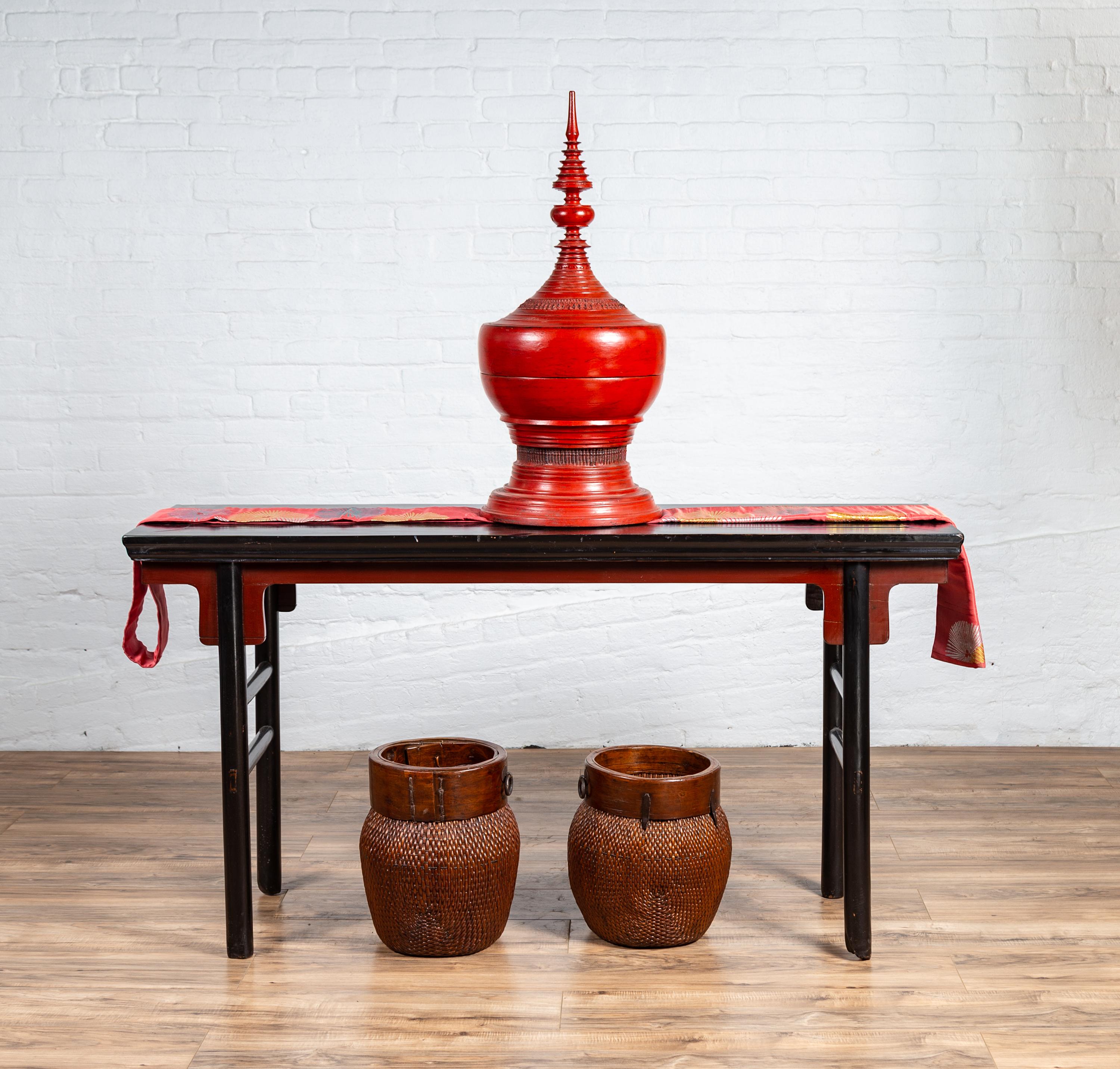 A Chinese Ming Dynasty style black lacquered altar console table from the early 20th century, with red accents. Charming us with is clean, simple lines and contrasting colors, this Chinese Ming style altar console table features a rectangular top