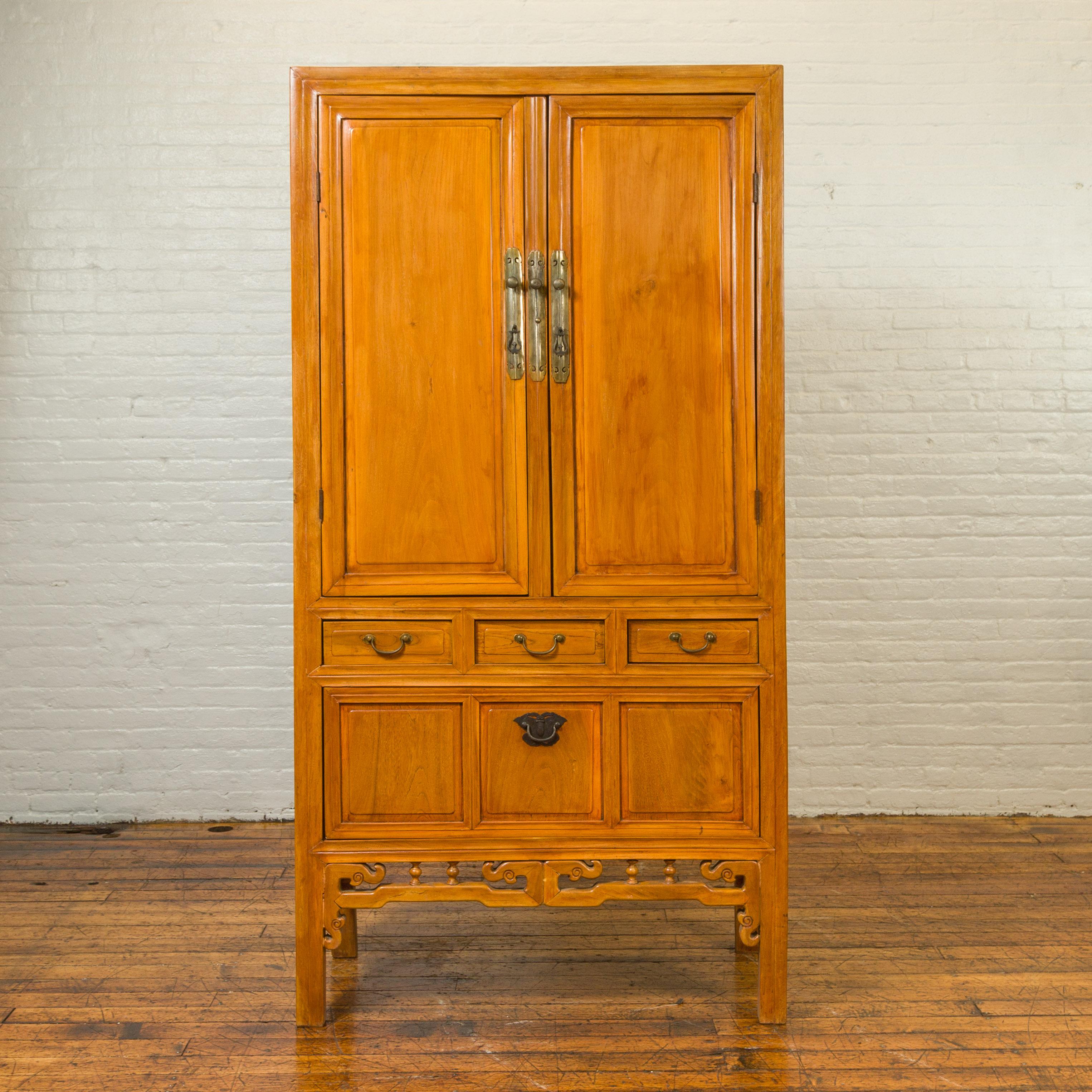 A Chinese Ming dynasty style elmwood antique cabinet from the 19th century, with two doors, drawers and lower removable panel. Crafted in China during the 19th century, this tall cabinet captures our attention with its warm elm finish and convenient