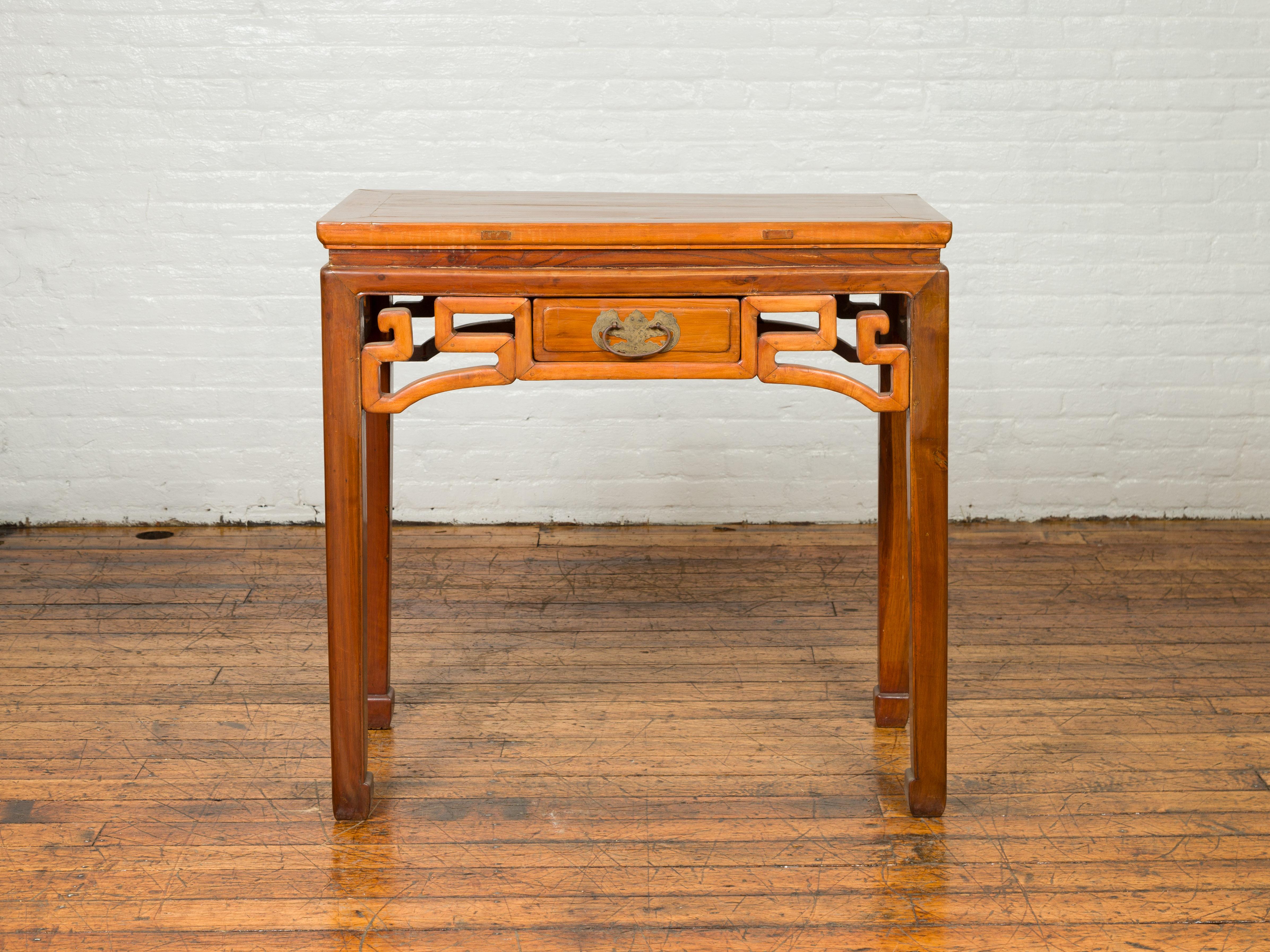 A Chinese Ming Dynasty style elmwood desk from the early 20th century, with single drawer, bronze butterfly hardware and horse hoofed feet. Born in China during the early years of the 20th century, this Ming style table features a rectangular
