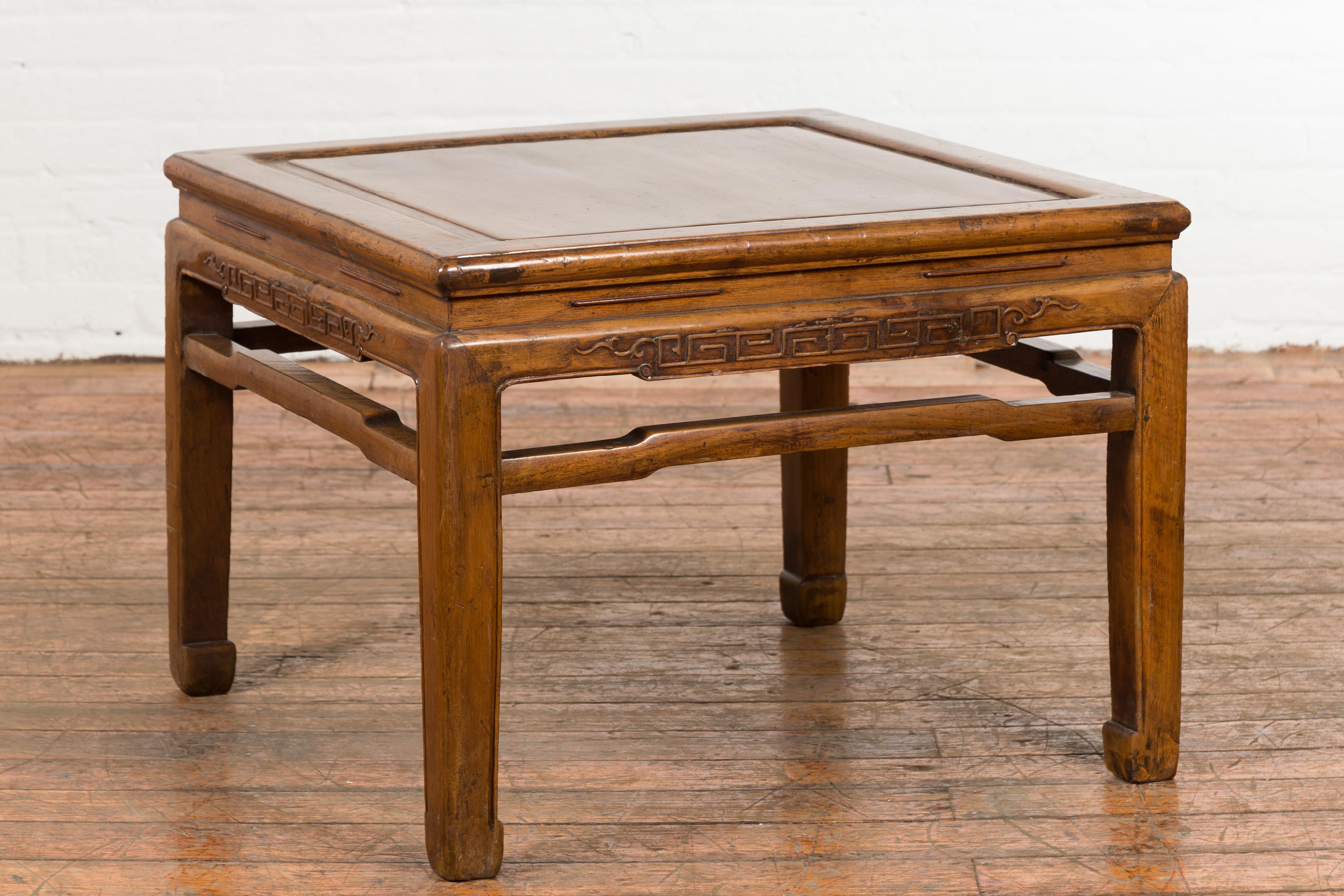 A Chinese vintage Ming Dynasty style low side table from the mid 20th century, with horse hoof extremities. Created in China during the midcentury period, this side table was originally conceived to be used as a stool. Featuring a waisted square top