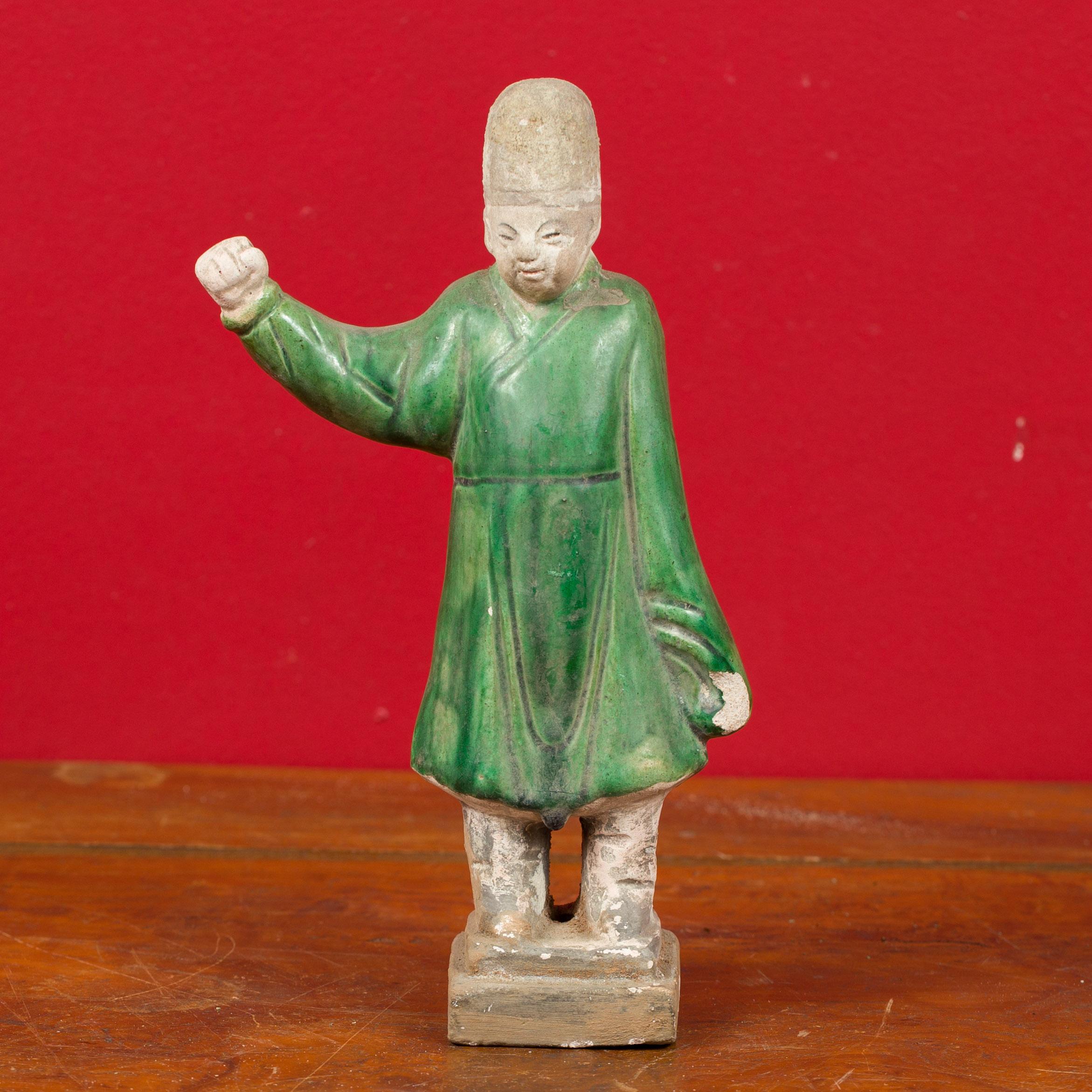 A petite Chinese Ming Dynasty green glazed terracotta court official figurine from the 15th or 16th century, with original polychromy. Attracting our eye with its nice polychromy, this Ming statuette features a court official standing proudly on a