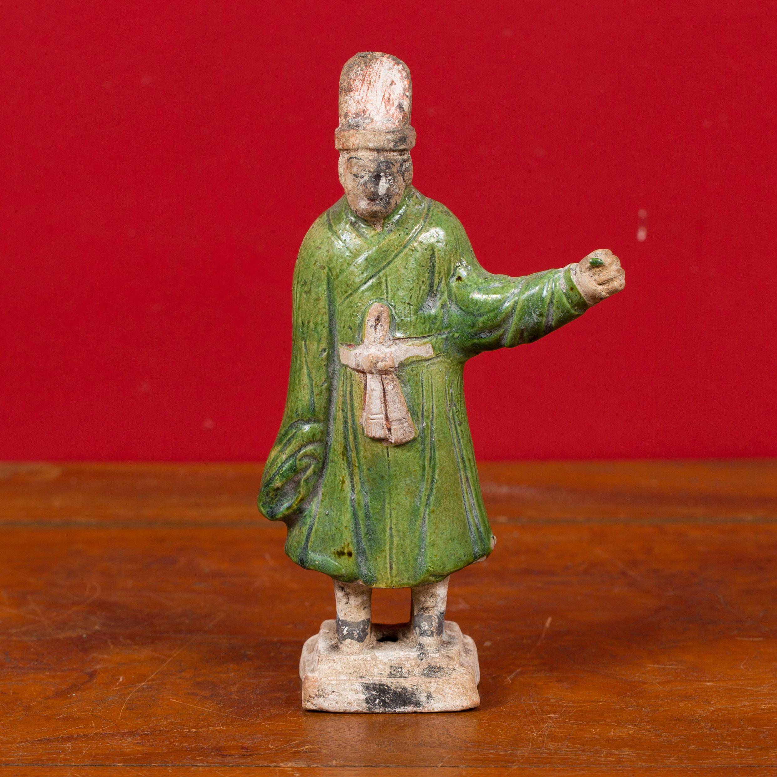 A petite Chinese Ming dynasty green glazed terracotta court official figurine from the 15th or 16th century, with original polychromy. Attracting our eye with its nice polychromy, this Ming statuette features a court official standing proudly on a