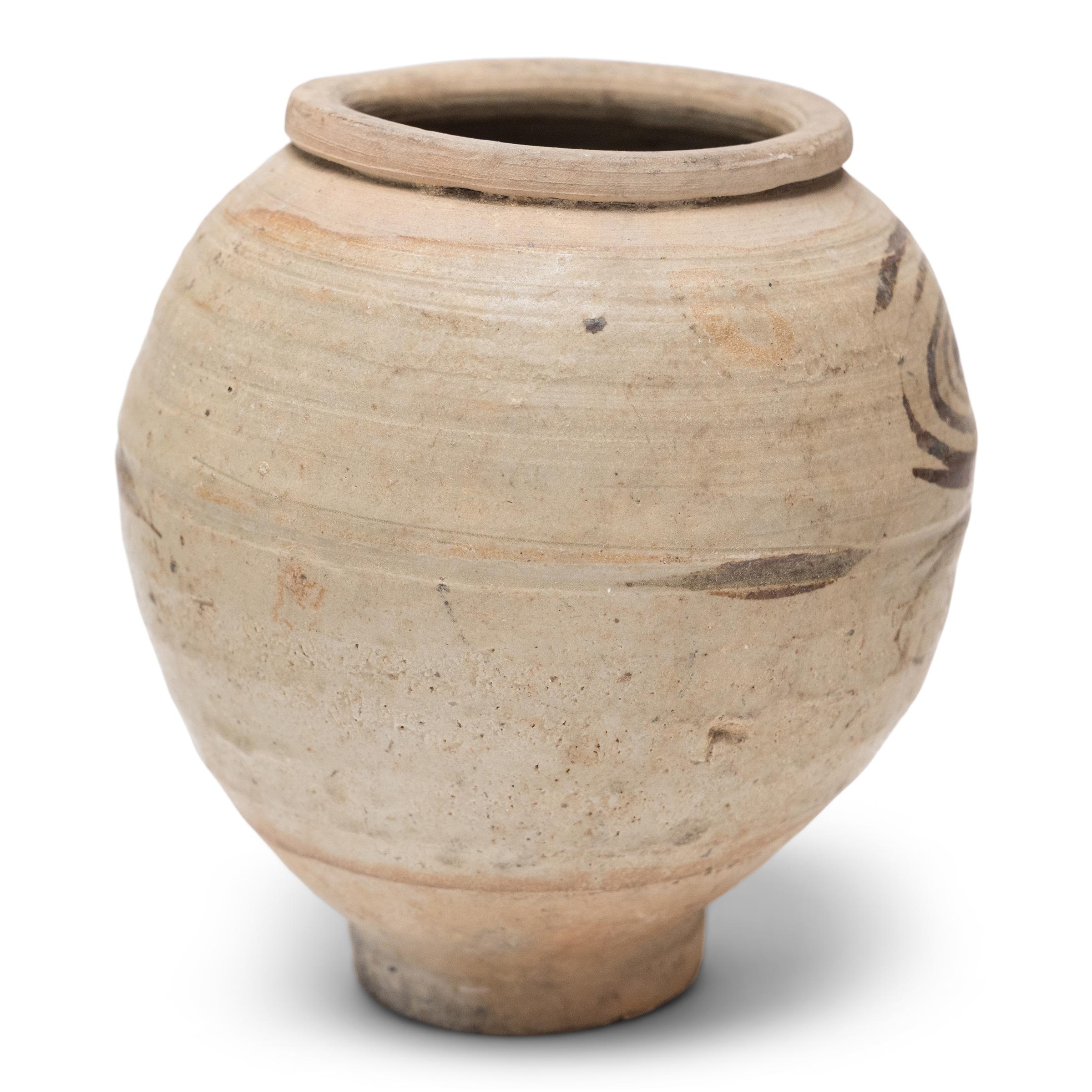 Cette jarre de stockage de la dynastie Ming (1368-1644) est attribuée aux fours de la province du Yunnan. Elle est vaguement décorée de sous-glaçure de fer d'une manière typique de la région. Datée du 15e/16e siècle, cette petite jarre est