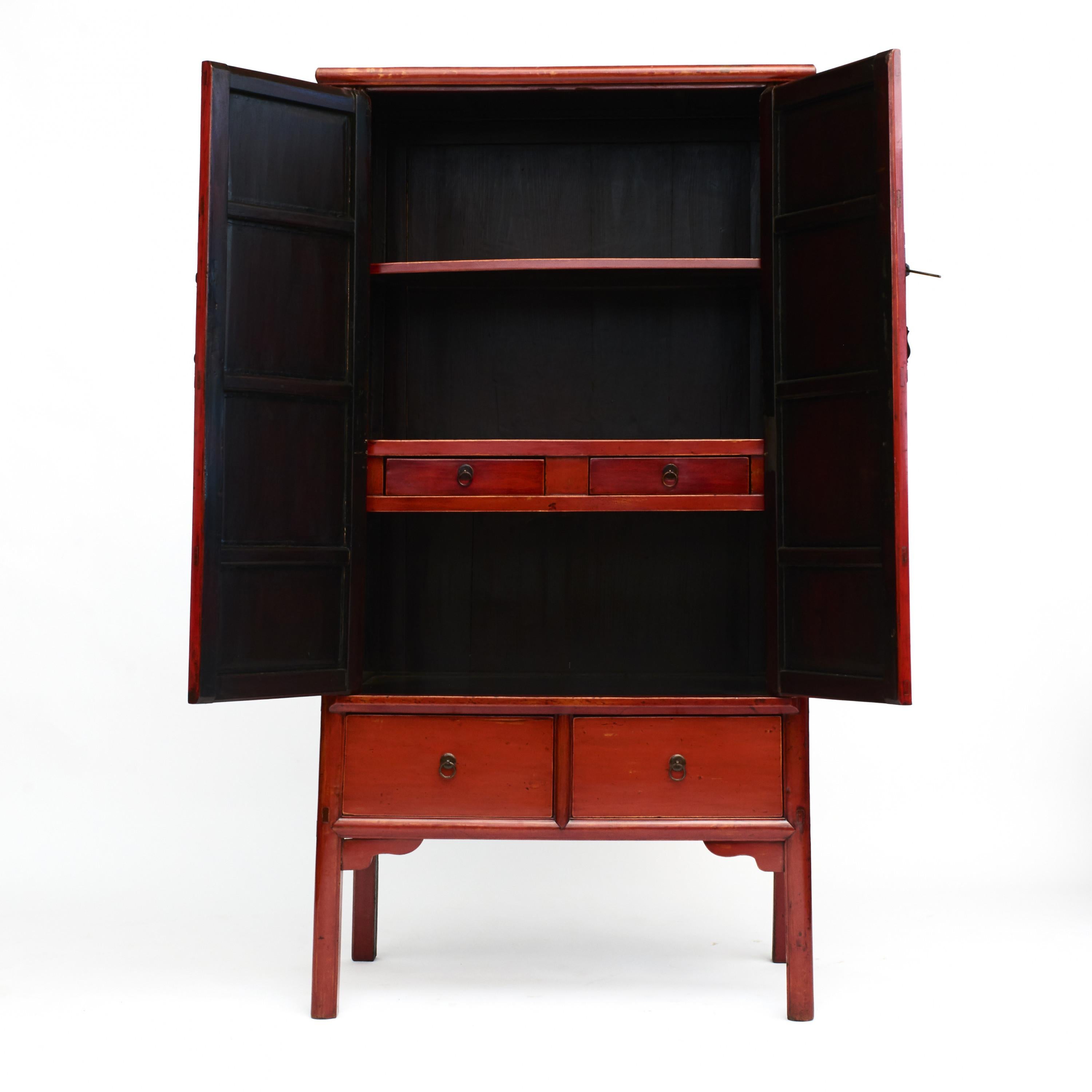 Beautiful elmwood cabinet with perfect original red lacquer.
Conical body with pair of doors fitted with metal hardware that opens to shelf storage area fitted with two drawers.
The lower section showcases two additional drawers adorned with ring