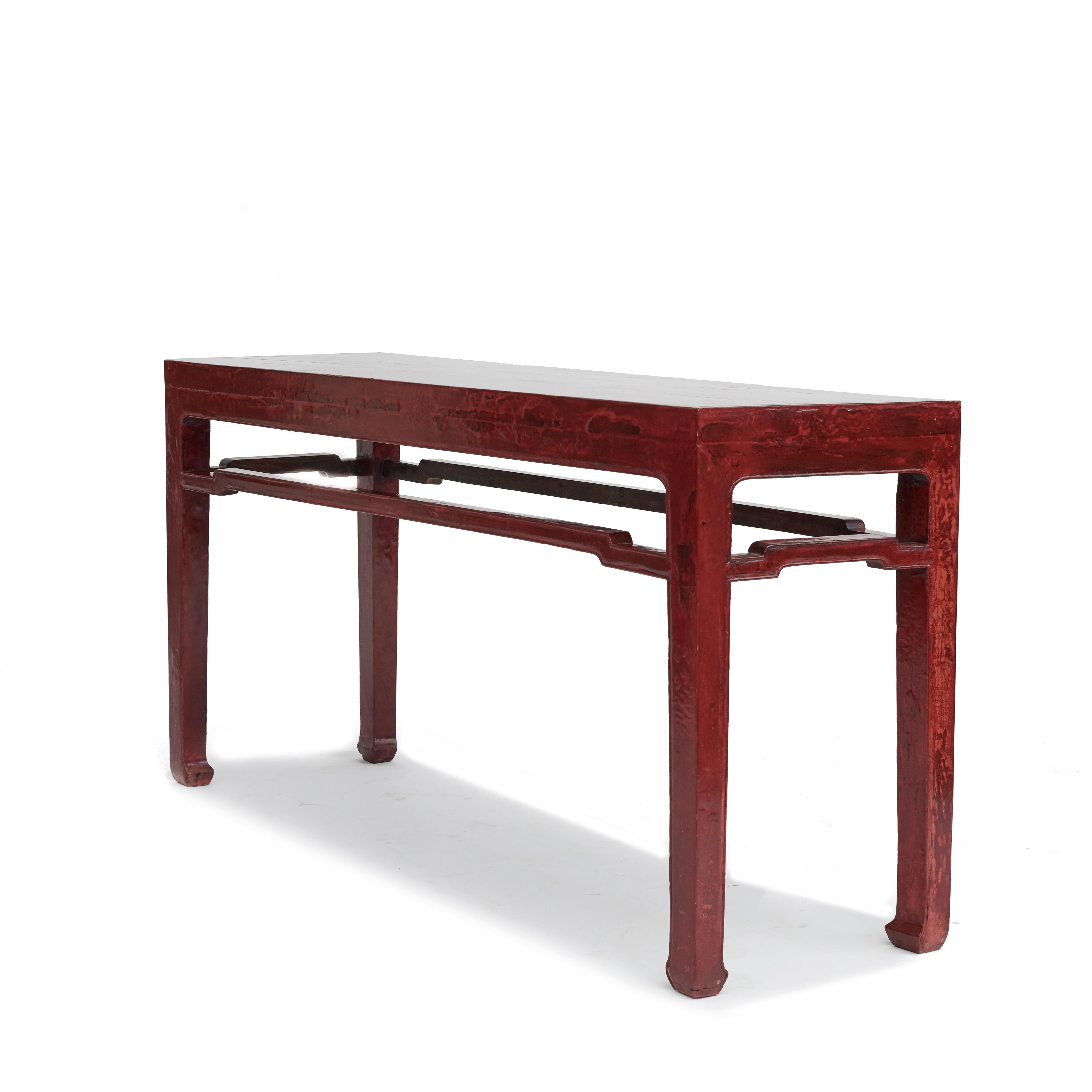 A freestanding ming style console table.
The table features humpback stretchers, horse hoof feet and original red lacquer with natural age-related patina.

Presumably made of ironwood, as it is very heavy. However, this is difficult to determine