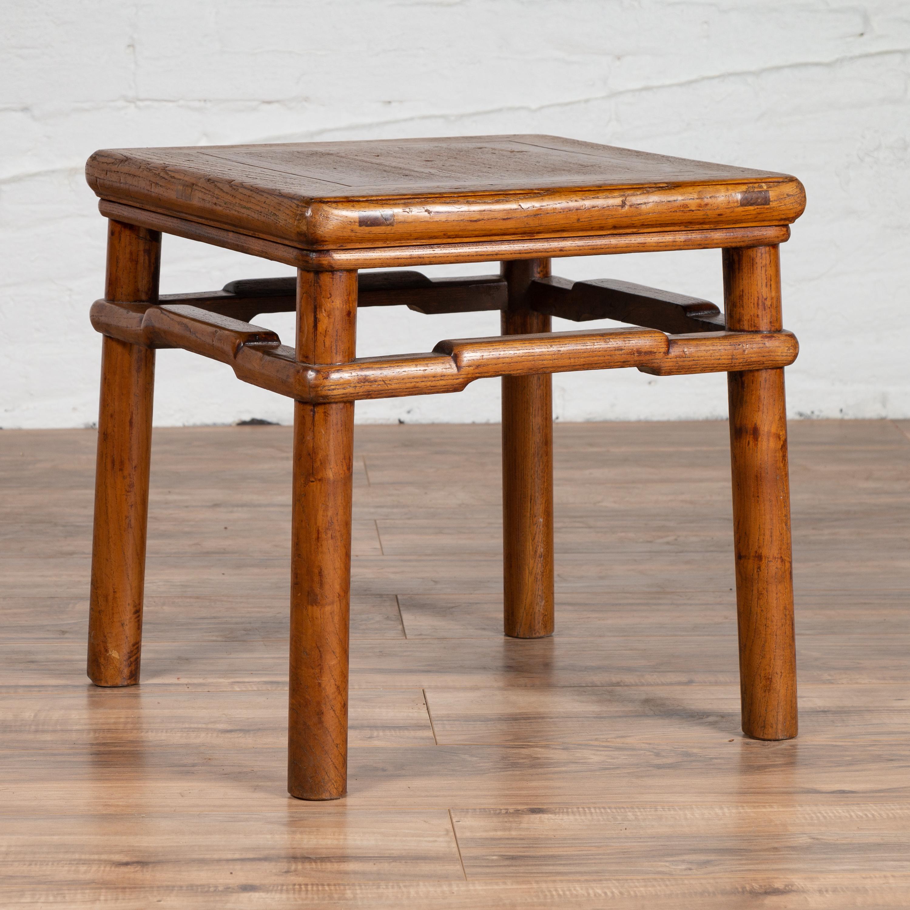 A vintage Chinese Ming dynasty style natural wood side table from the mid-20th century, with humpbacked stretcher, rich grain and cylindrical legs. Born in China during the mid-century period, this charming side table features a square top with