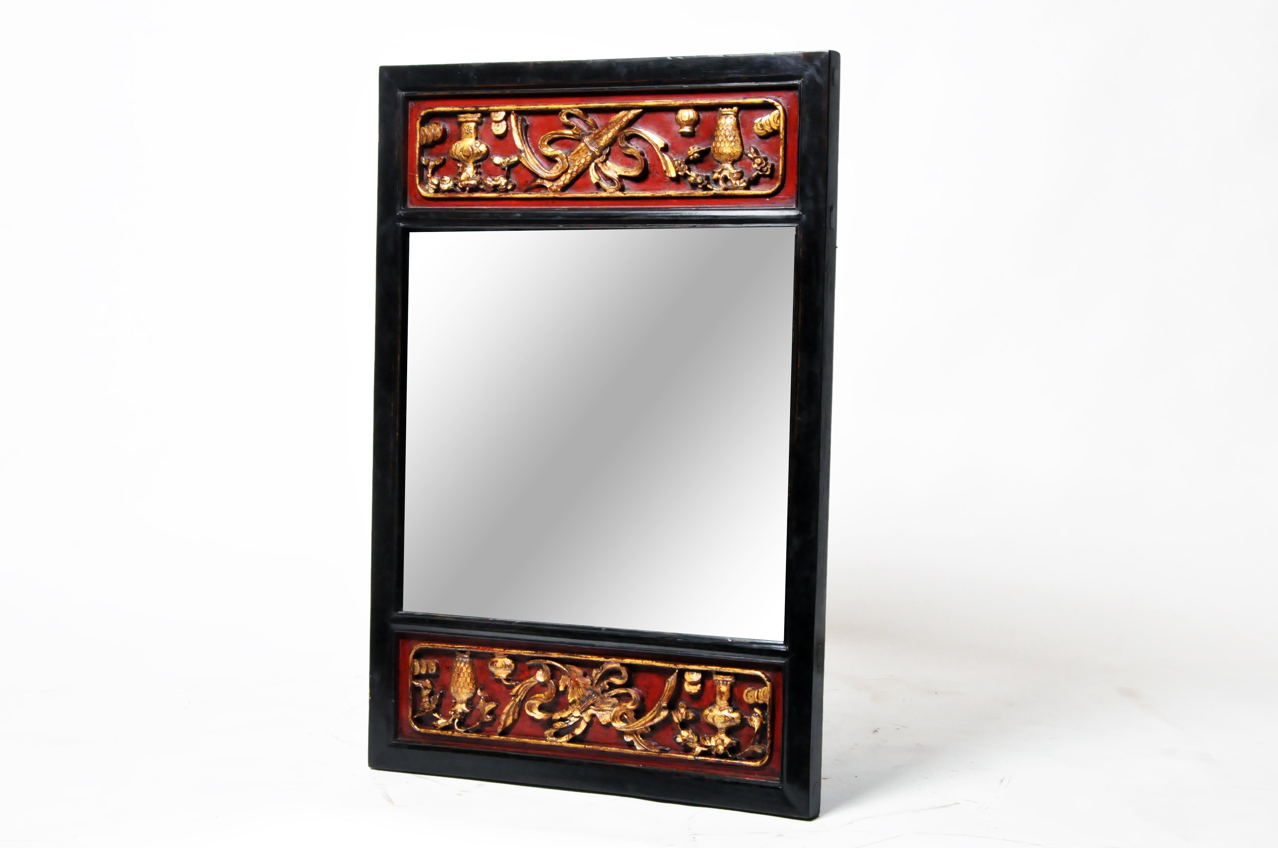 This gilt-and-lacquer carved wooden mirror is actually part of an old interior wall in a Chinese mansion. It is carved with auspicious symbols and restored with a French polish finish. The mirror glass is new but the old frame probably dates to