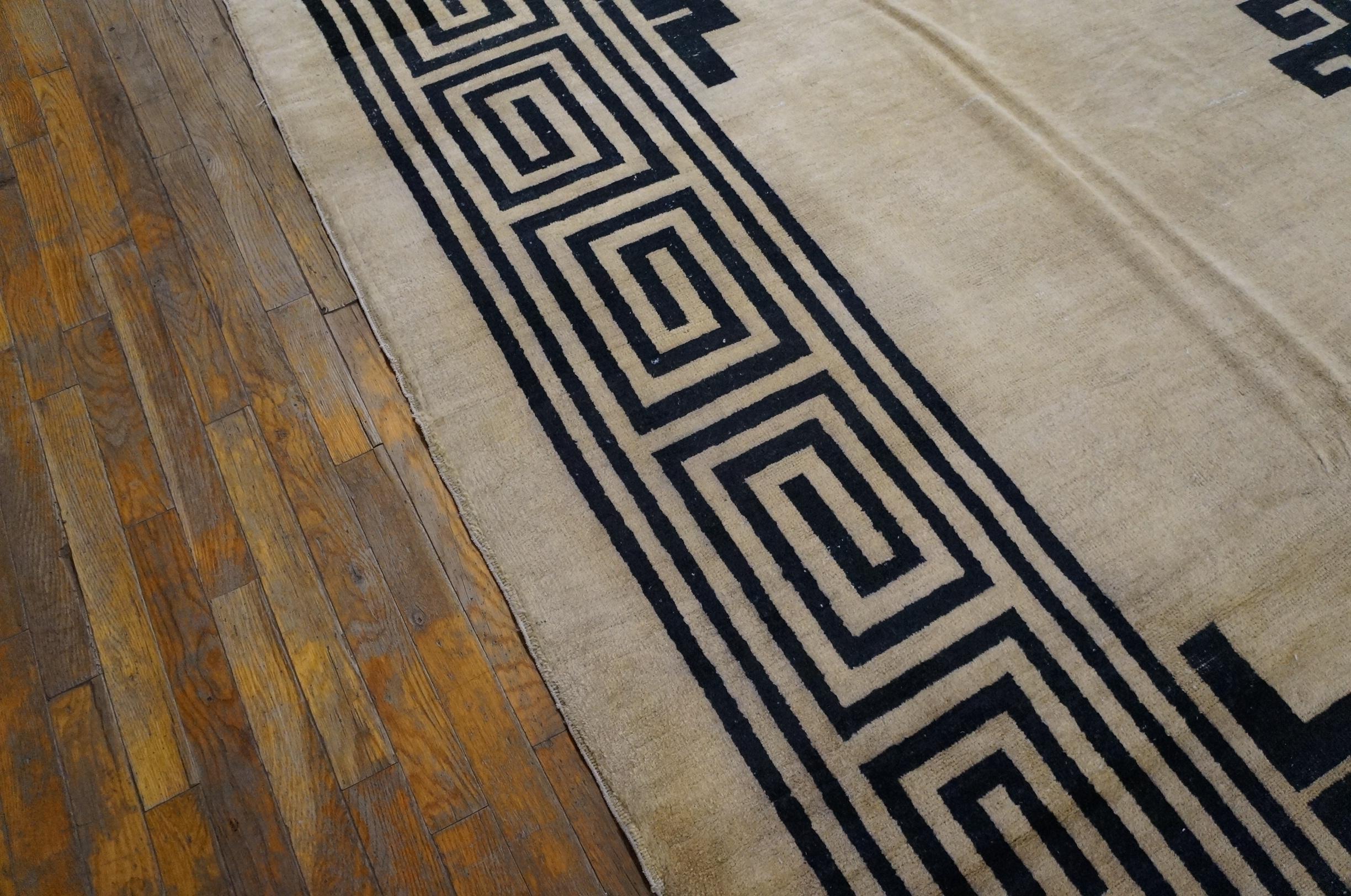 This ivory and black two tone carpet is boldly abstract with a powerful fret medallion (and matching corners) on an unornamented ivory ground, encompassed by a giant T-fret border. This rug was Art Deco before Deco. This circa 1900 northeastern