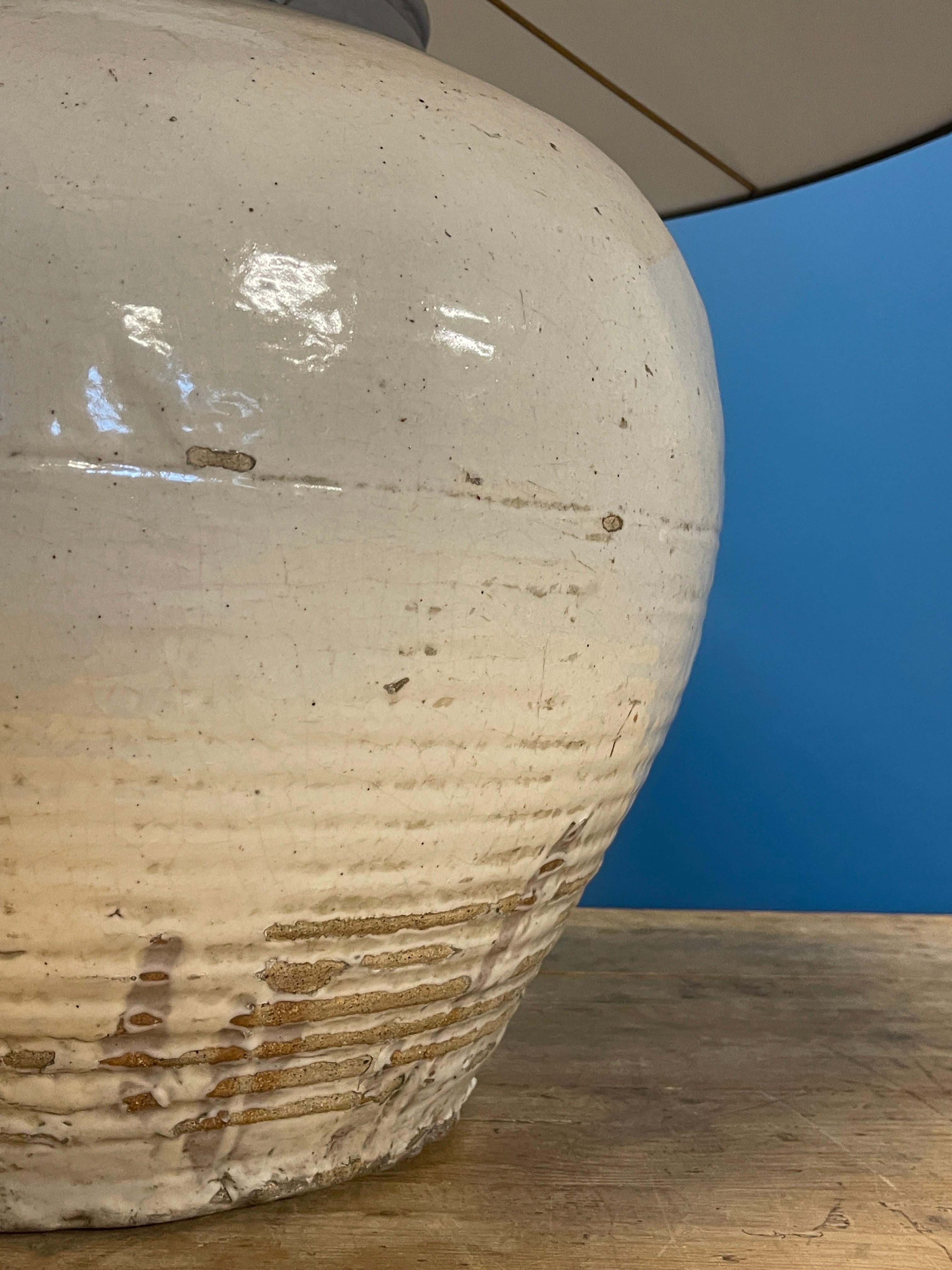 Un grand vase bulbeux chinois monochrome à glaçure crème, 18e/19e C.