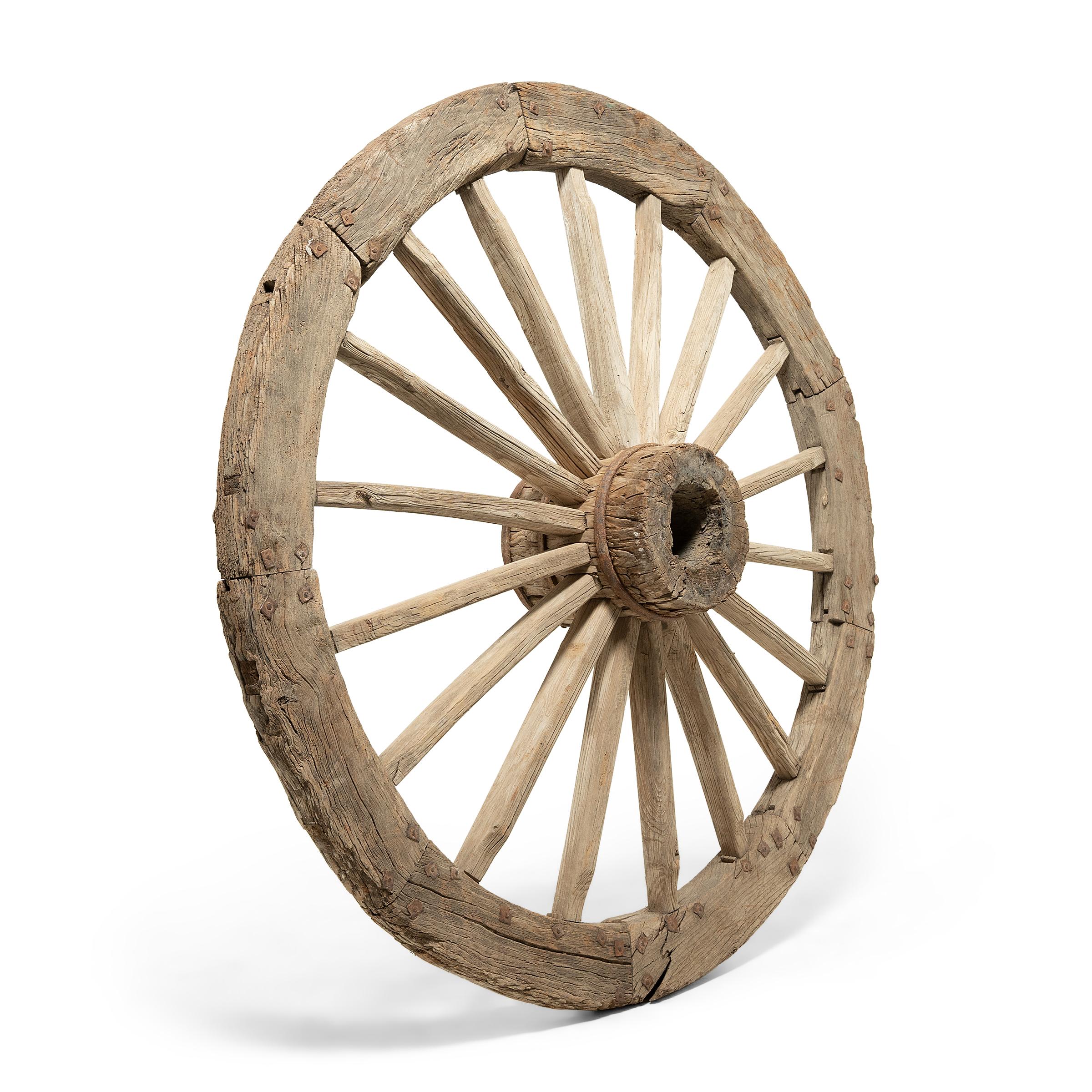 Hewn from pine and held together with handmade iron nails, this provincial wooden wheel is a remarkable example of turn-of-the-century craftsmanship. Its monumental scale suggests it was used not as a wagon wheel, but as a turning element of a