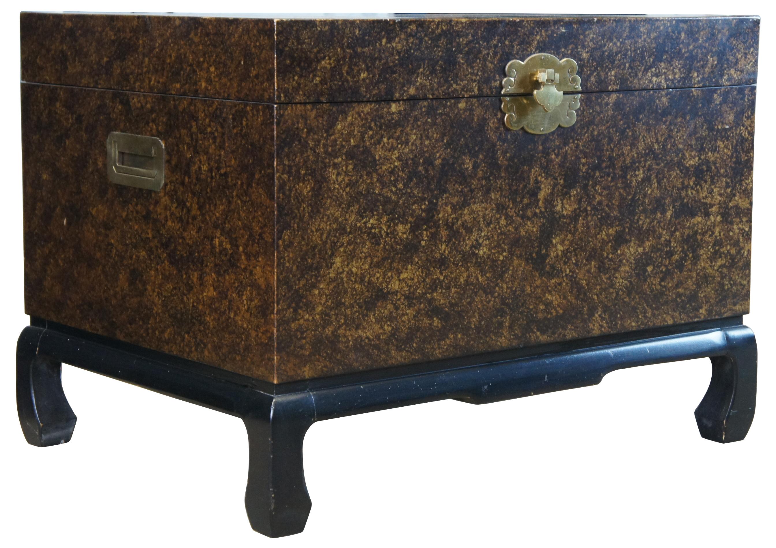 Late 20th century Chinese trunk on stand. Made from hardwood with a mottled gold finish and black lacquer Ming style base. Includes brass hardware with recessed brass handles along each side. Box is mounted to base.