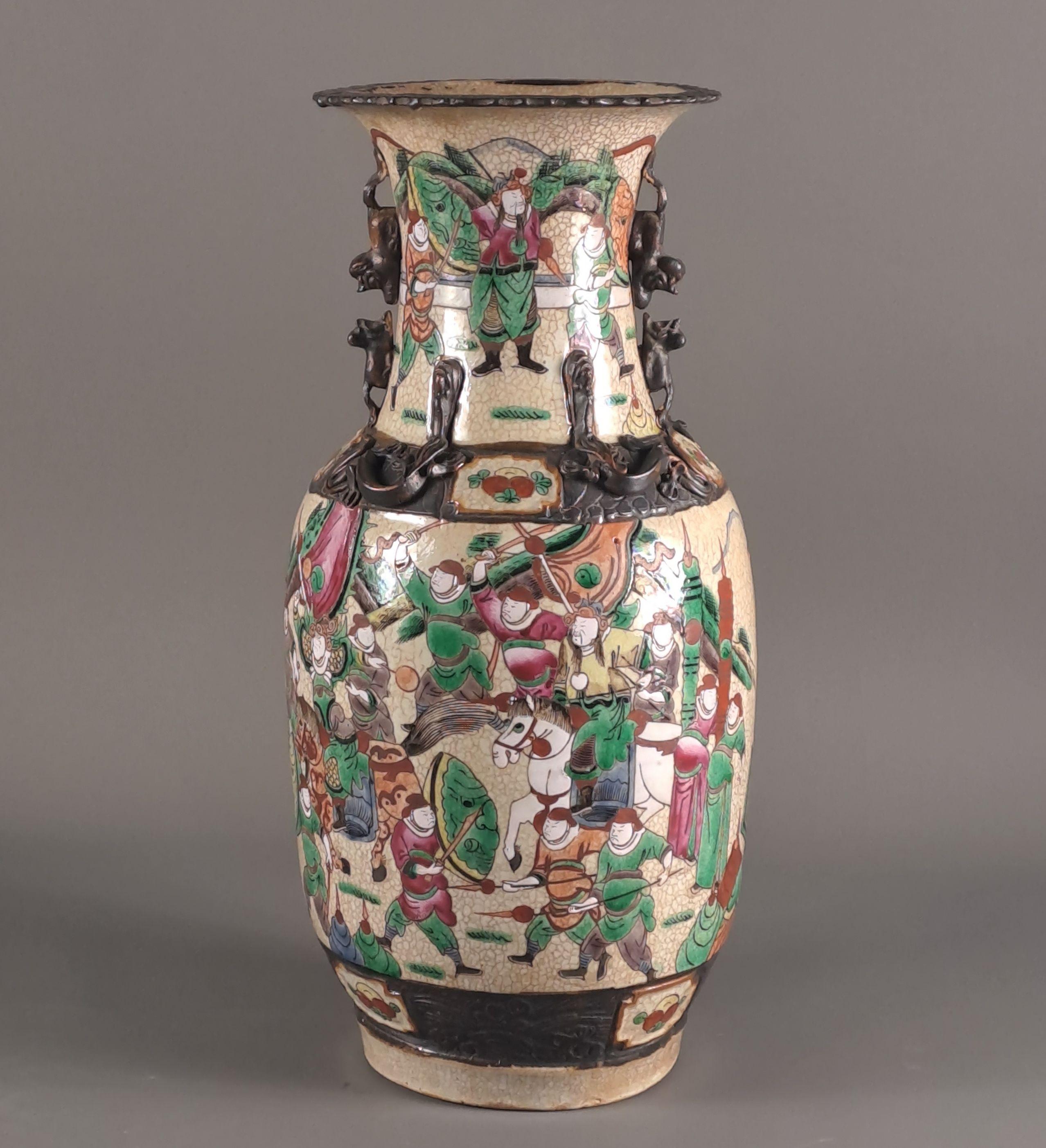 Baluster-shaped vase in Nanjing porcelain with a beige crackled background and rich polychrome decoration of warriors.
Fô dogs and phoenix in relief on the shoulder, brown friezes on the base, the shoulder and the collar.

Nanjing, 19th