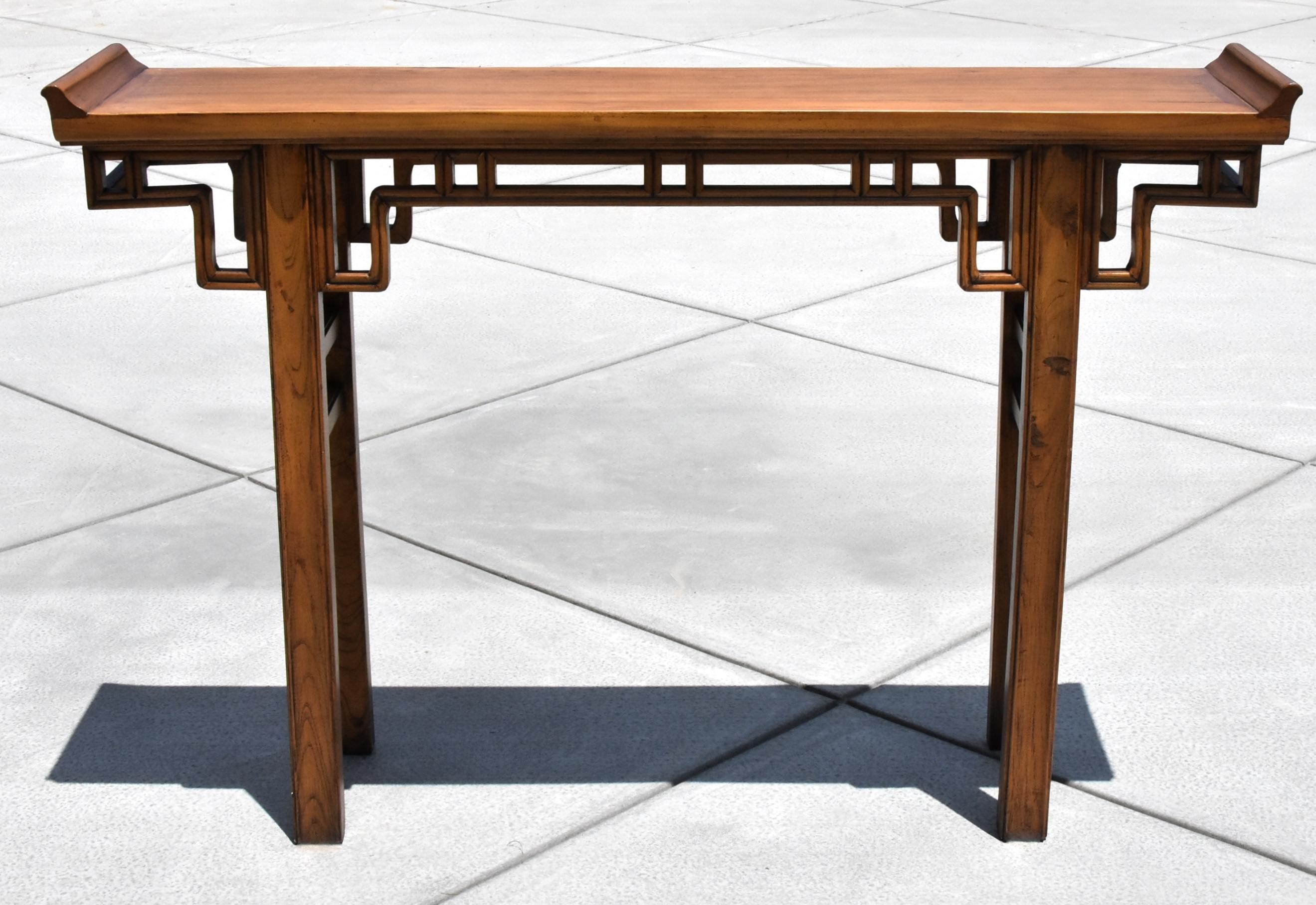 Beautiful double sided Chinese altar table. Its geometric scroll design originates from the Ming dynasty. Slightly raised flanges give the nod to the Chinese temple architecture. The choice of wood is the valued elm wood, with its graceful grains
