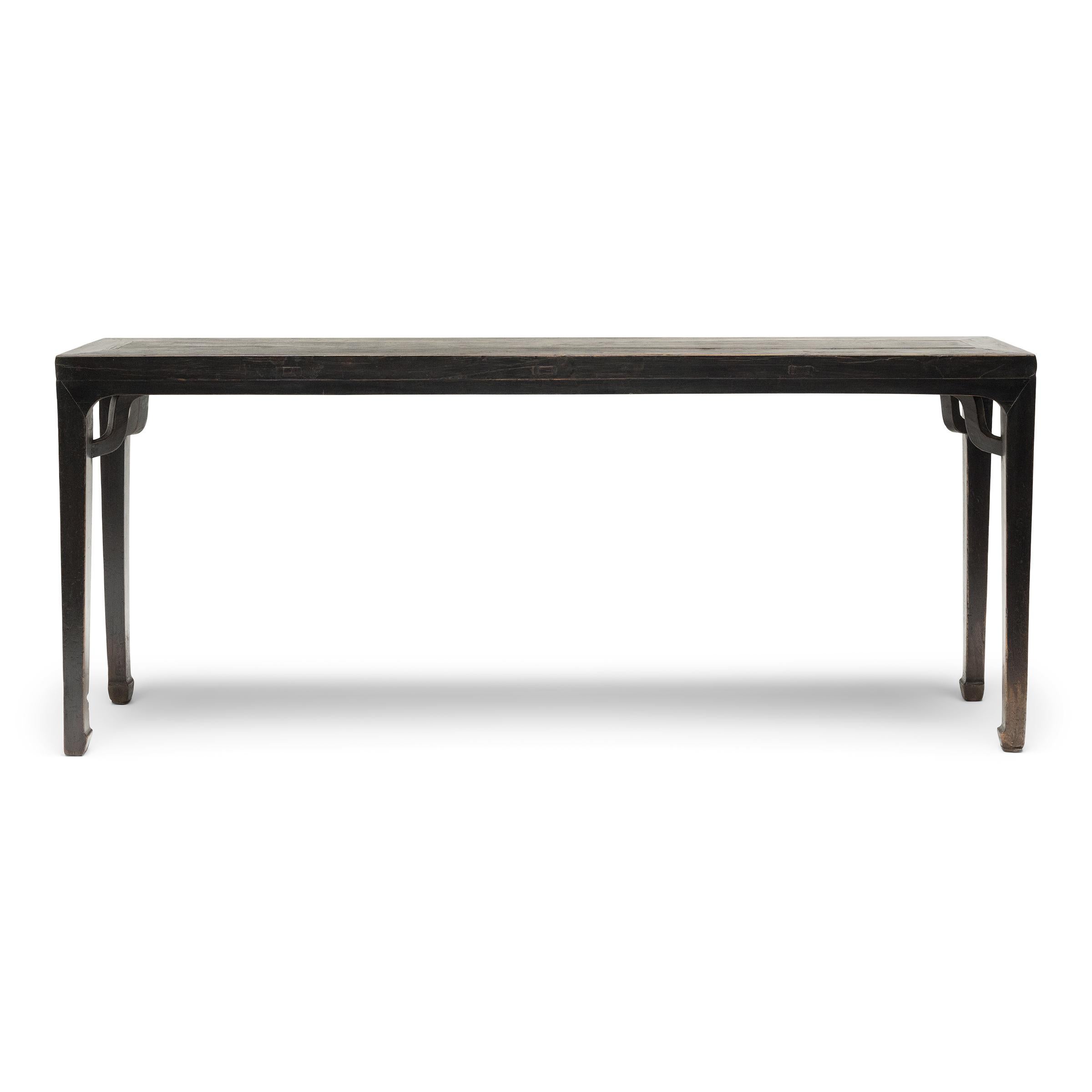 This slender painting table from the early 19th-century exemplifies the timeless elegance of classical Chinese furniture forms. With its long surface ideal for contemplating scrolls and paintings, the table likely once resided in a scholar's studio,