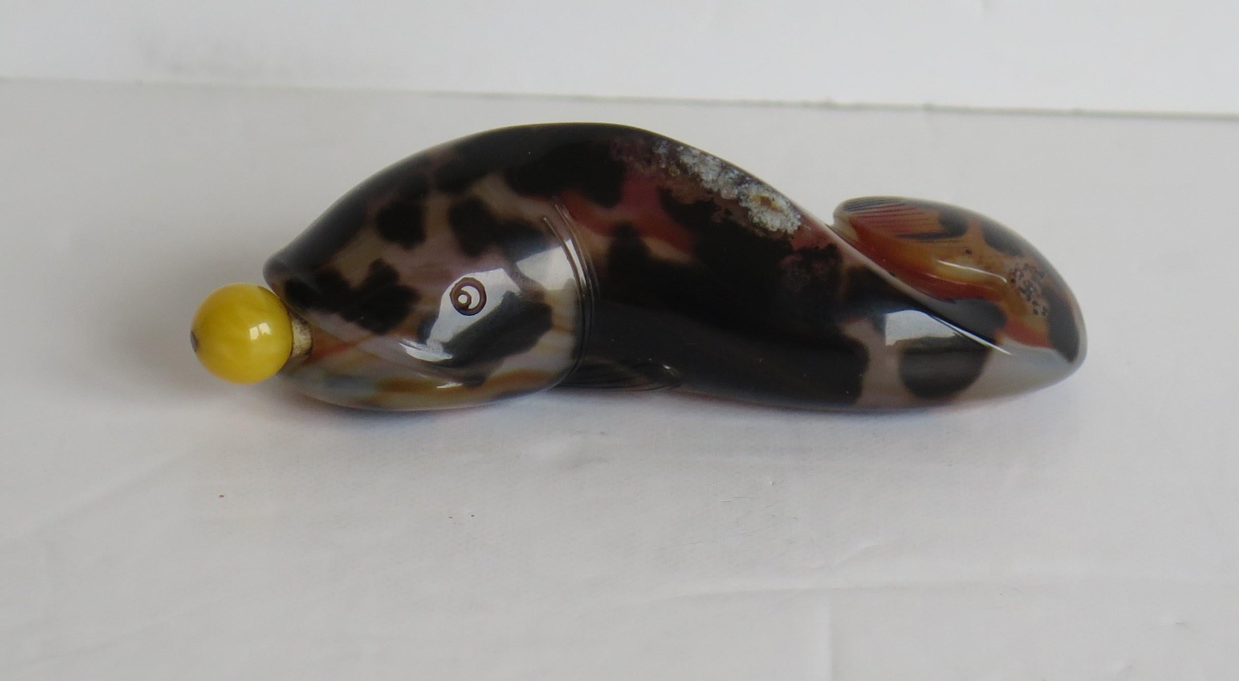 This is a beautiful Chinese Export snuff bottle hand carved from a natural agate stone in the form of a fish, having lovely veined colors and complete with its spoon top, which we date to the first half of the 20th century, circa 1940.

The bottle