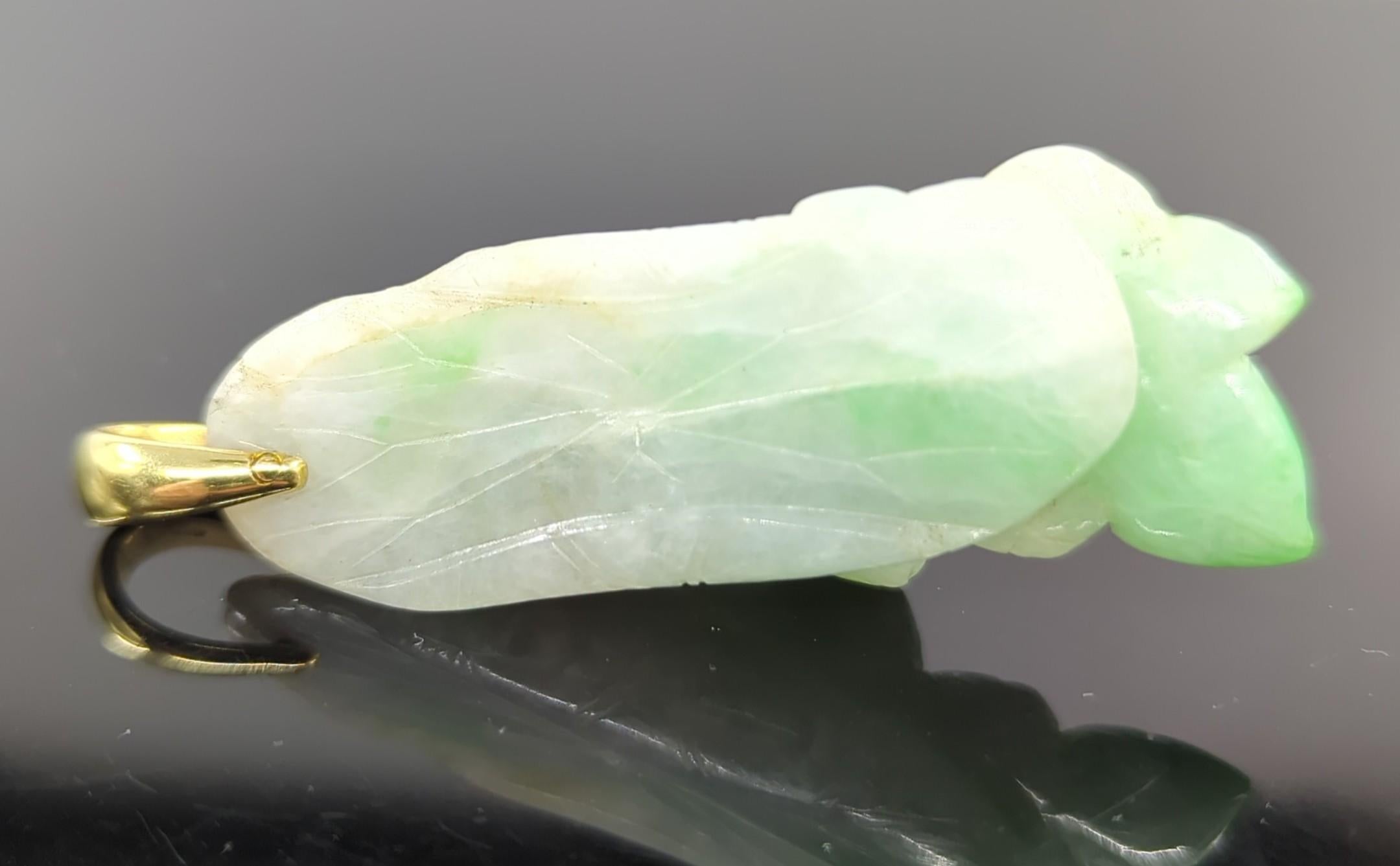 Chinese jadeite pendant, hand carved in the form of a lotus blossom in the front, and back carved with a lotus leaf with curling edges. 

The jadeite carving is 19th century or earlier, and untreated with natural apple green color inclusions.

The