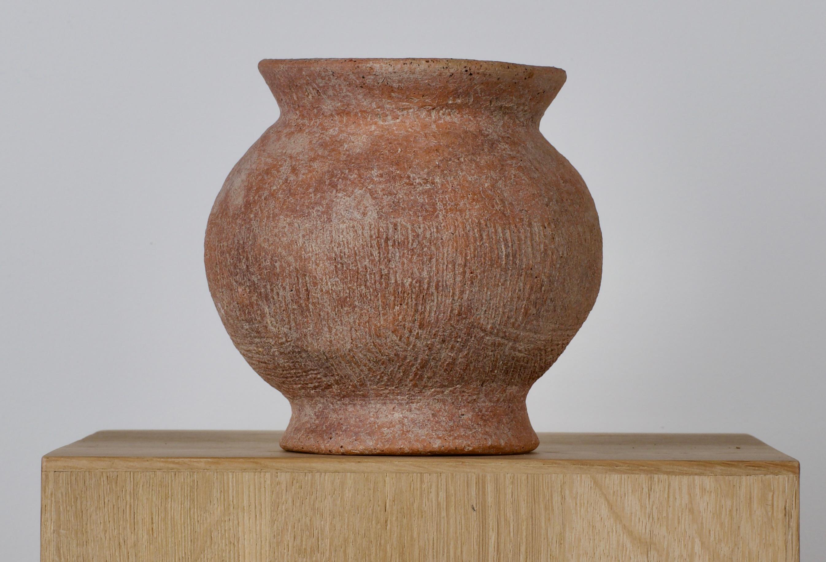 Rounded jar with flared rim and base from 2nd millennium B.C. or later. Leather texture to the body. 
