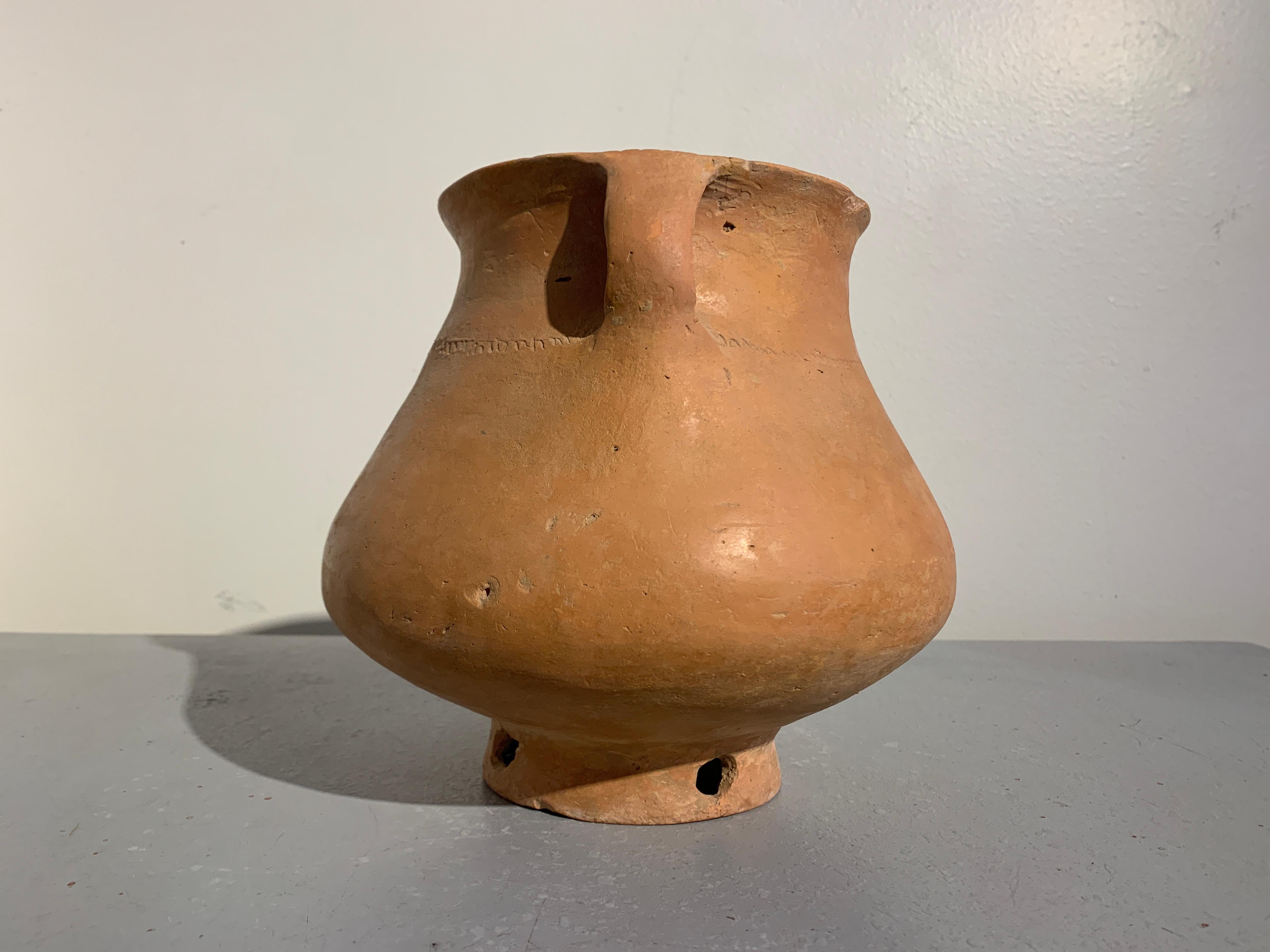 An attractive Neolithic Chinese burnished red pottery vessel, Qijia Culture (2200 BC - 1600 BC), modern day Gansu Province, China.

The vessel of compressed globular form set on a short, pieced pedestal foot, and featuring two ear handles, a short,