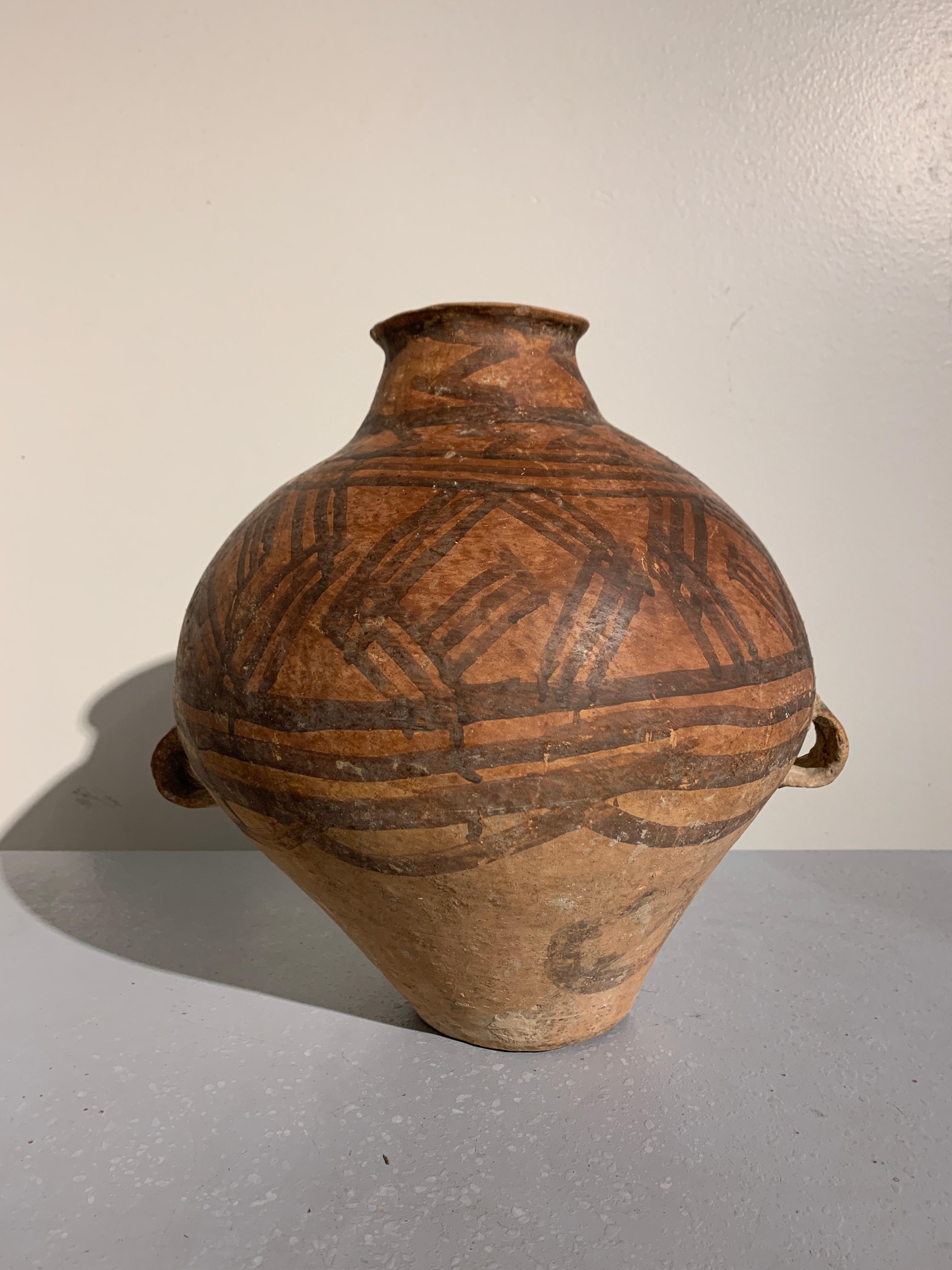 A rustic Chinese Neolithic bronze age pottery amphora with painted geometric design, Yangshao Culture (5000-3000 BC), circa 3500 BC, China.

The vessel of amphora form, with a narrow neck and two strap handles. The body of baluster form, with
