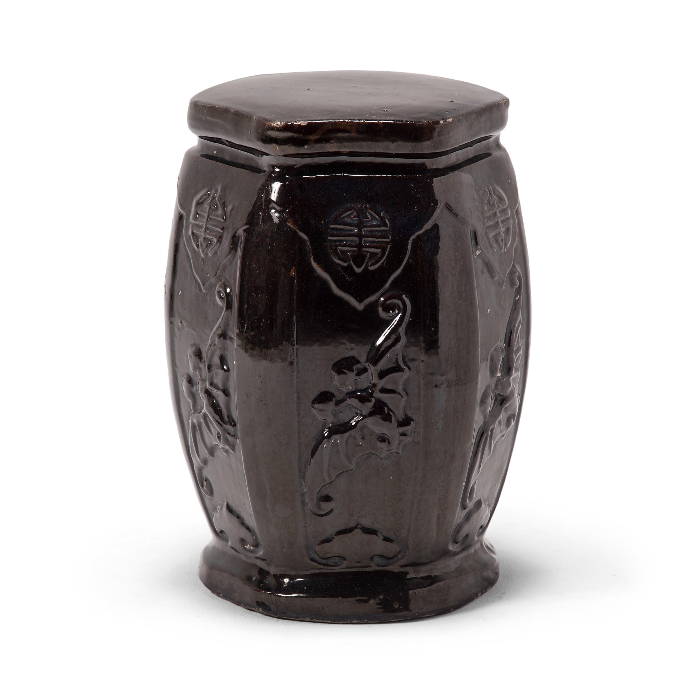 This early 20th century garden stool from China's Hebei province has the proportions of a traditional drum-form stool, but its hexagonal shape and waisted ends make it an unusual find. Although the dark glaze appears perfectly even from afar, a