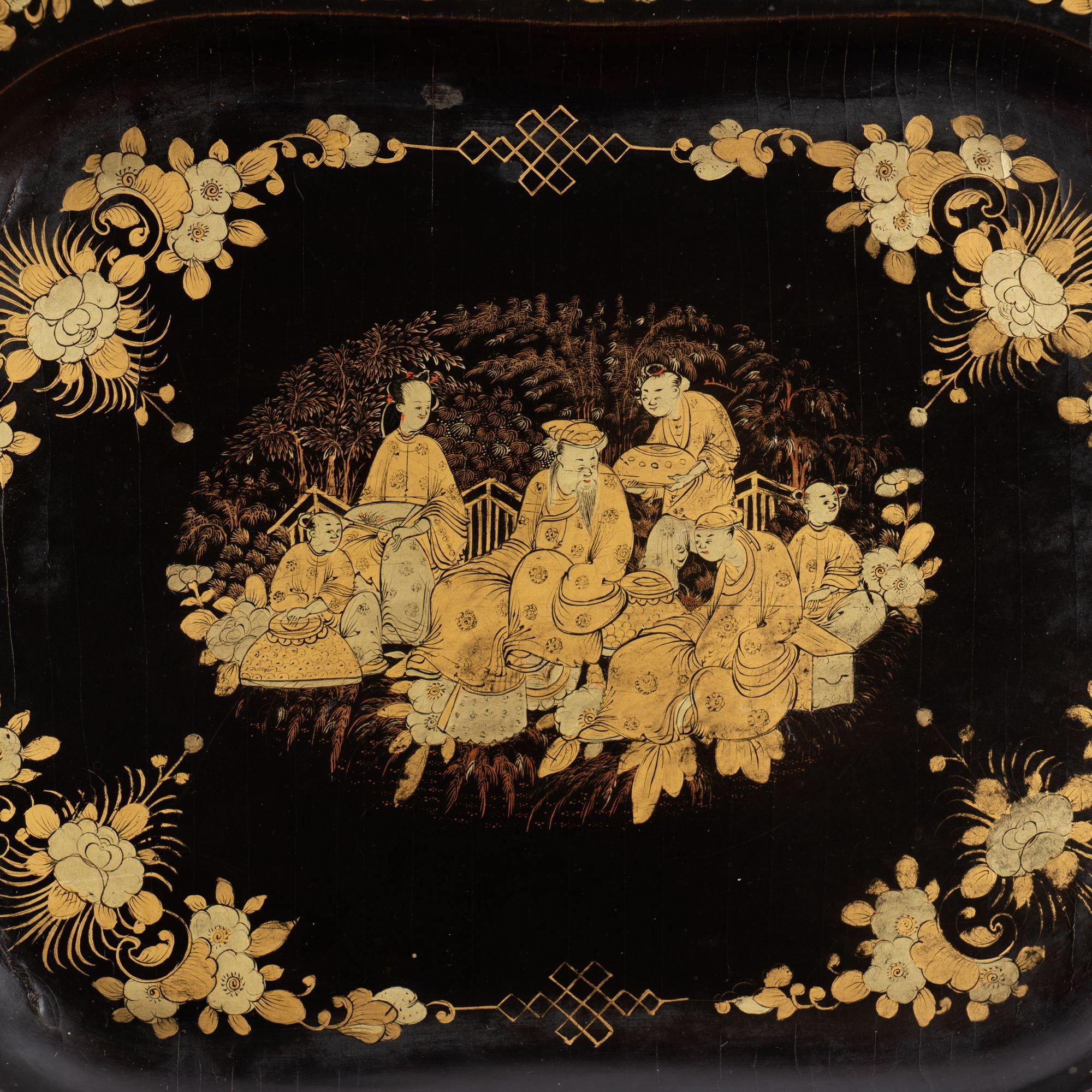 Chinese octagonal gilt decorated black lacquer tray with shaped border. A largely symmetrical floral border design frames a gathering of people at the center of the tray.

China, made for the Western trade, circa 1825.
