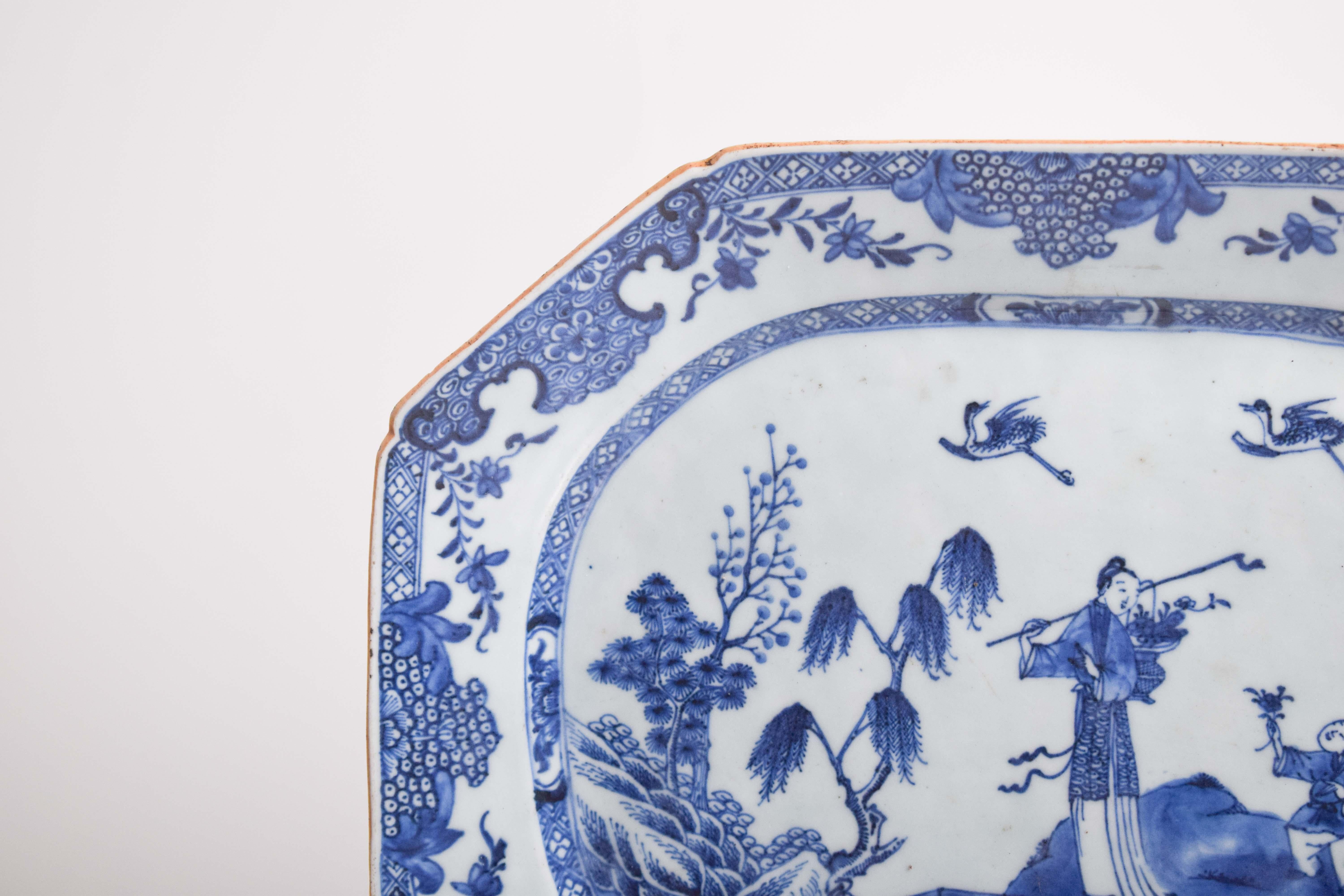This octagonal porcelain serving dish, crafted in Chinese porcelain for the East India Company, exemplifies the elegance of 18th-century export wares. The intricate blue-and-white decoration showcases traditional Chinese motifs, including graceful