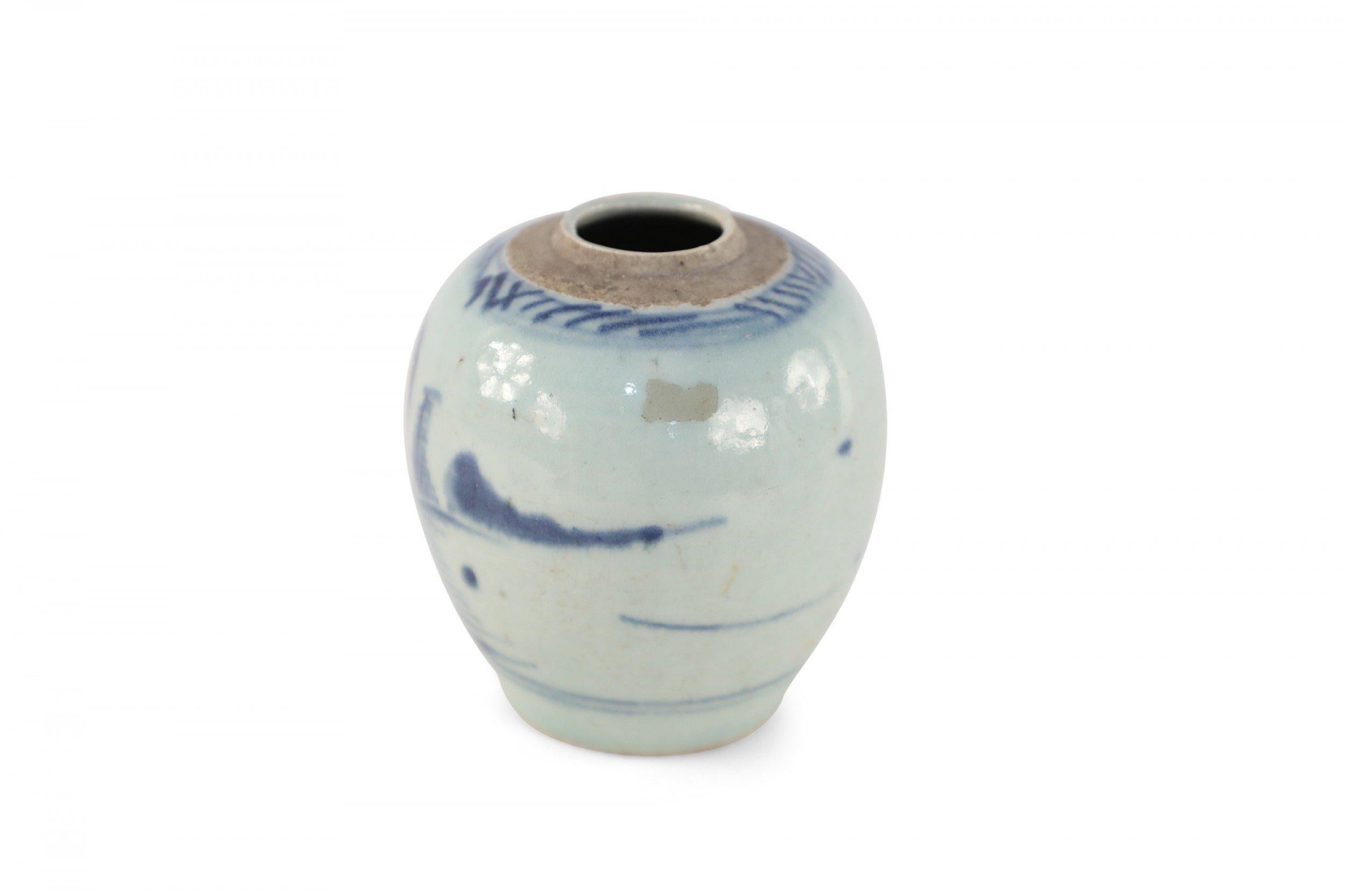Antique Chinese (Early 20th Century) small, porcelain jar depicting a blue pastoral scene on an off-white background with an unglazed rim.
  