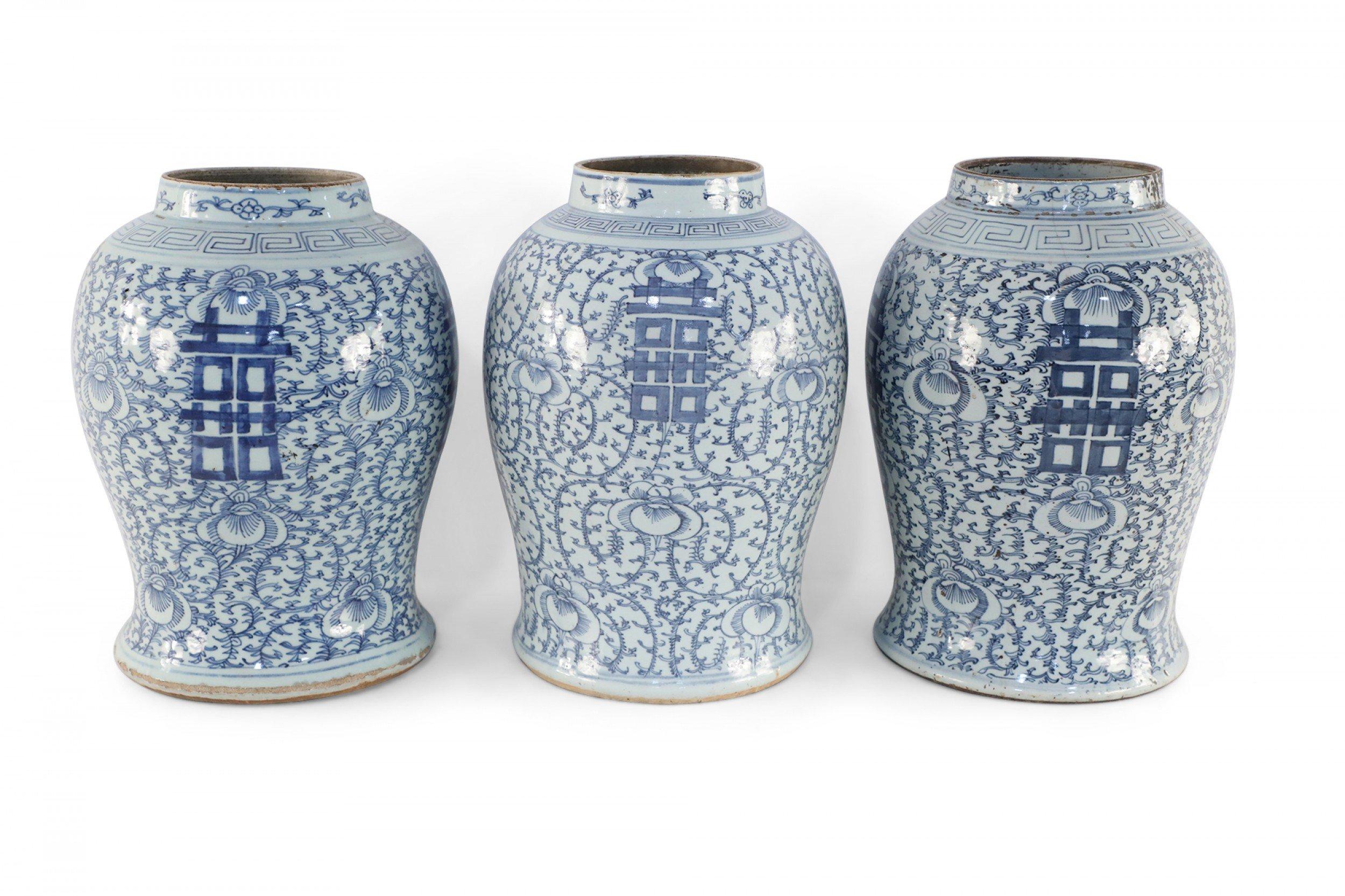 4 similar antique Chinese (Early 20th Century) off-white ceramic vases with urn forms decorated in light blue, delicate vine and floral motifs and bold characters on 4 sides (jars vary slightly in size, pattern, and color)(Priced each).
 