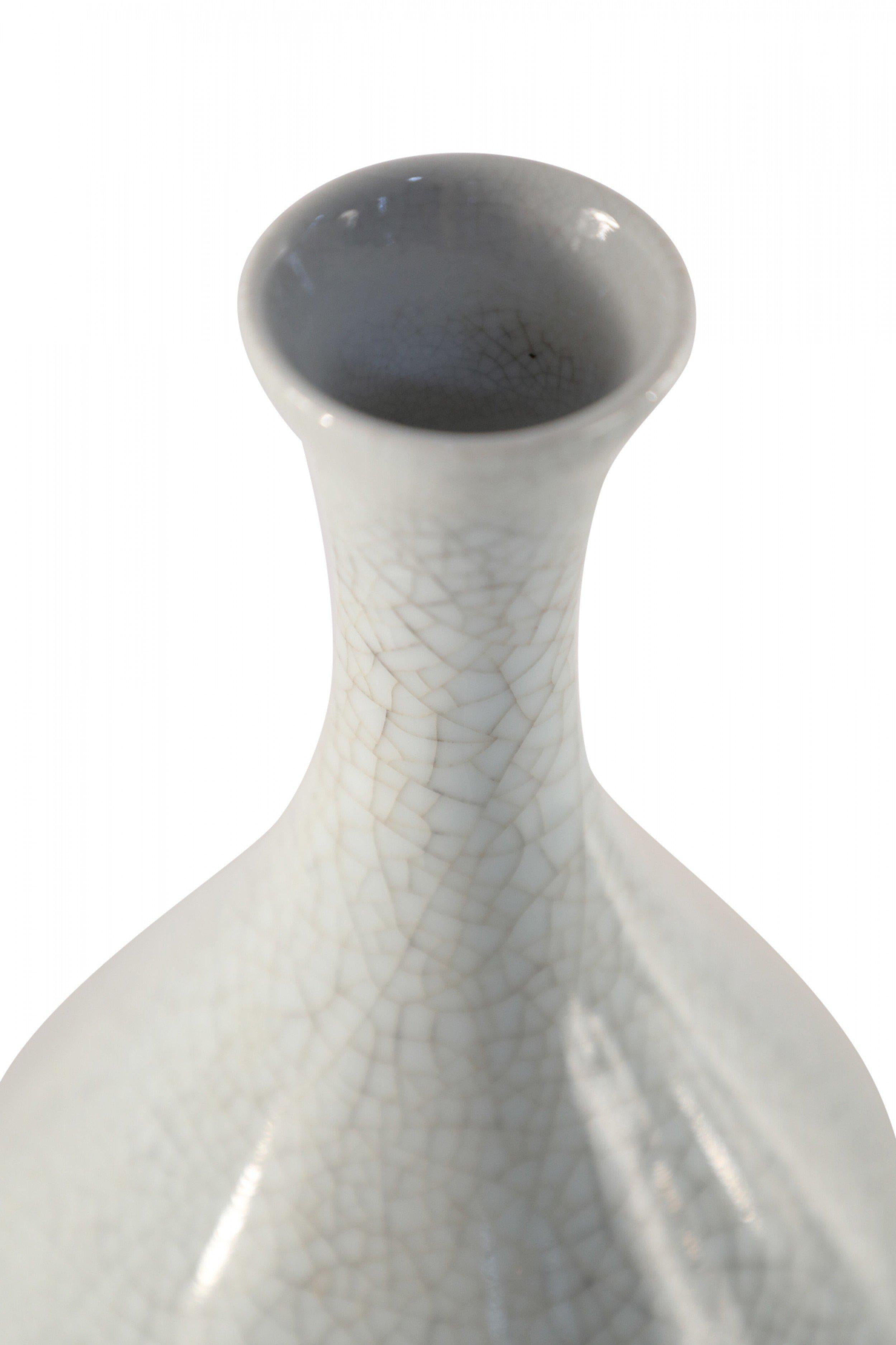 Chinese teardrop-shaped porcelain vase with an off-white crackle finish, a fluted opening and a hole in the base.
   