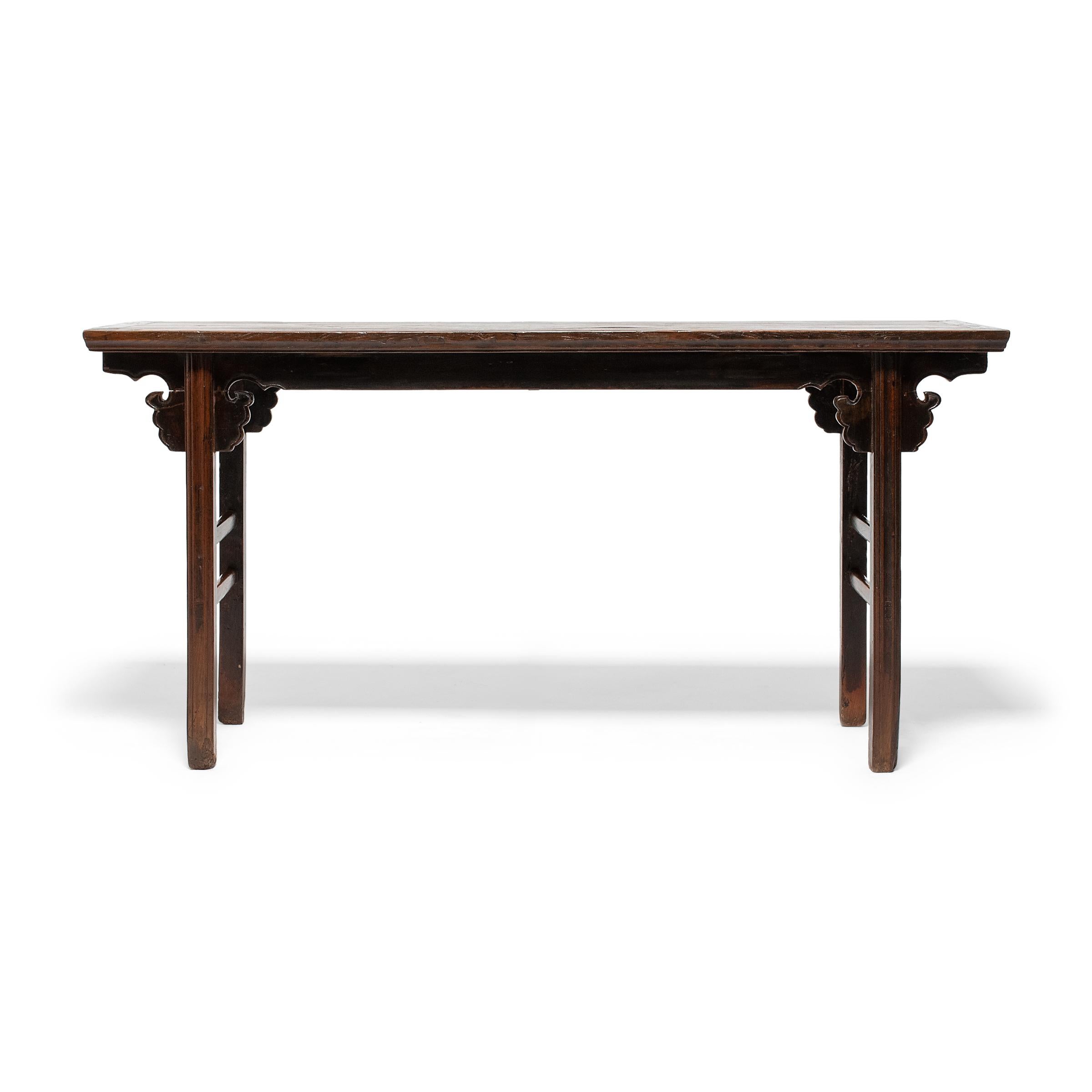 This late 19th-century offering table from Beijing expresses Ming-dynasty tastes with clean lines and a simple silhouette. Minimally decorated, the table features straight legs, double stretchers, and spandrels carved in the form of an auspicious