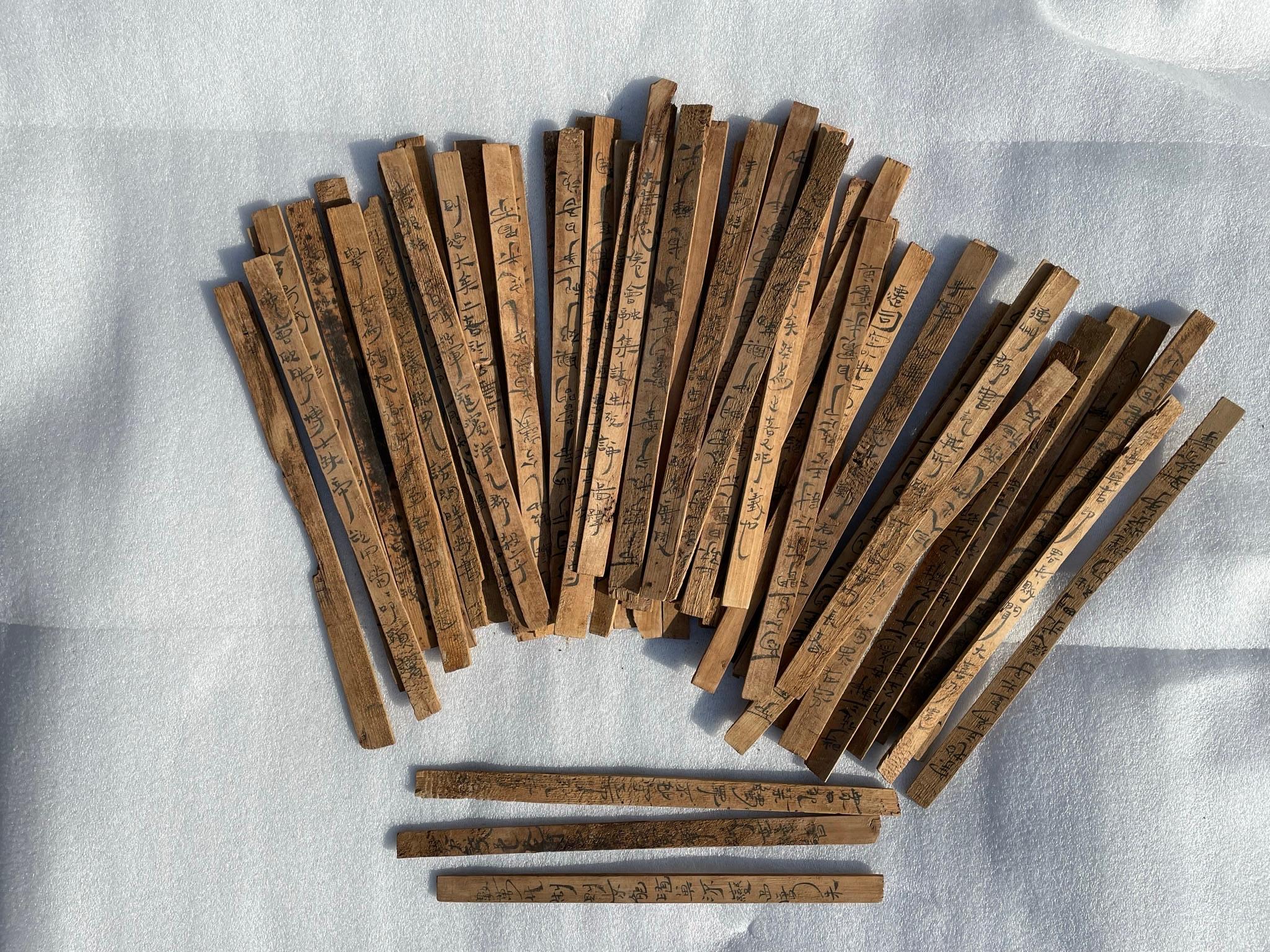 Bambus und hölzerne Zettel - jiandú - waren in China vor der weit verbreiteten Einführung von Papier in den ersten beiden Jahrhunderten n. Chr. das Hauptmedium zum Schreiben von Dokumenten.

Diese beachtliche Gruppe von 59 Exemplaren einzigartiger