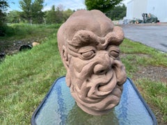 Scultura fantastica cinese antica con volto contorto