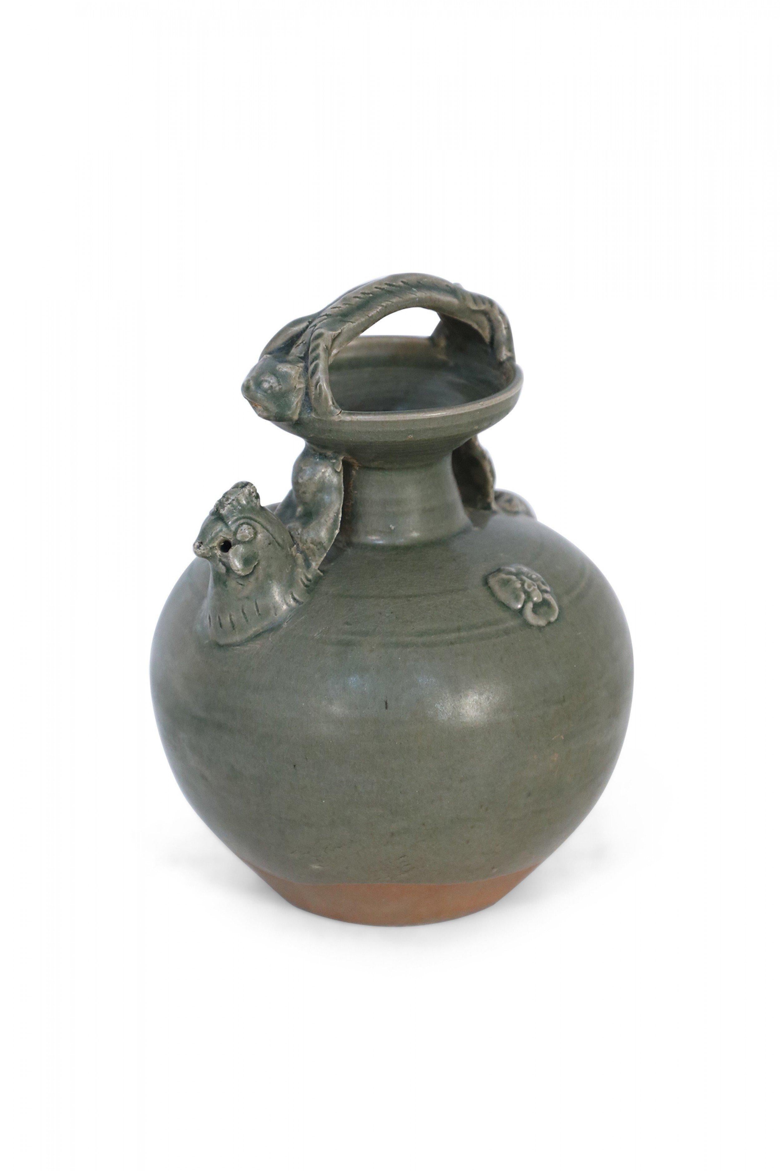 Pichet chinois en céramique vert olive, formé d'une anse s'étirant sur la bouche et d'une ouverture pour le contenu à l'intérieur d'une tête de poulet émergeant sur le côté.